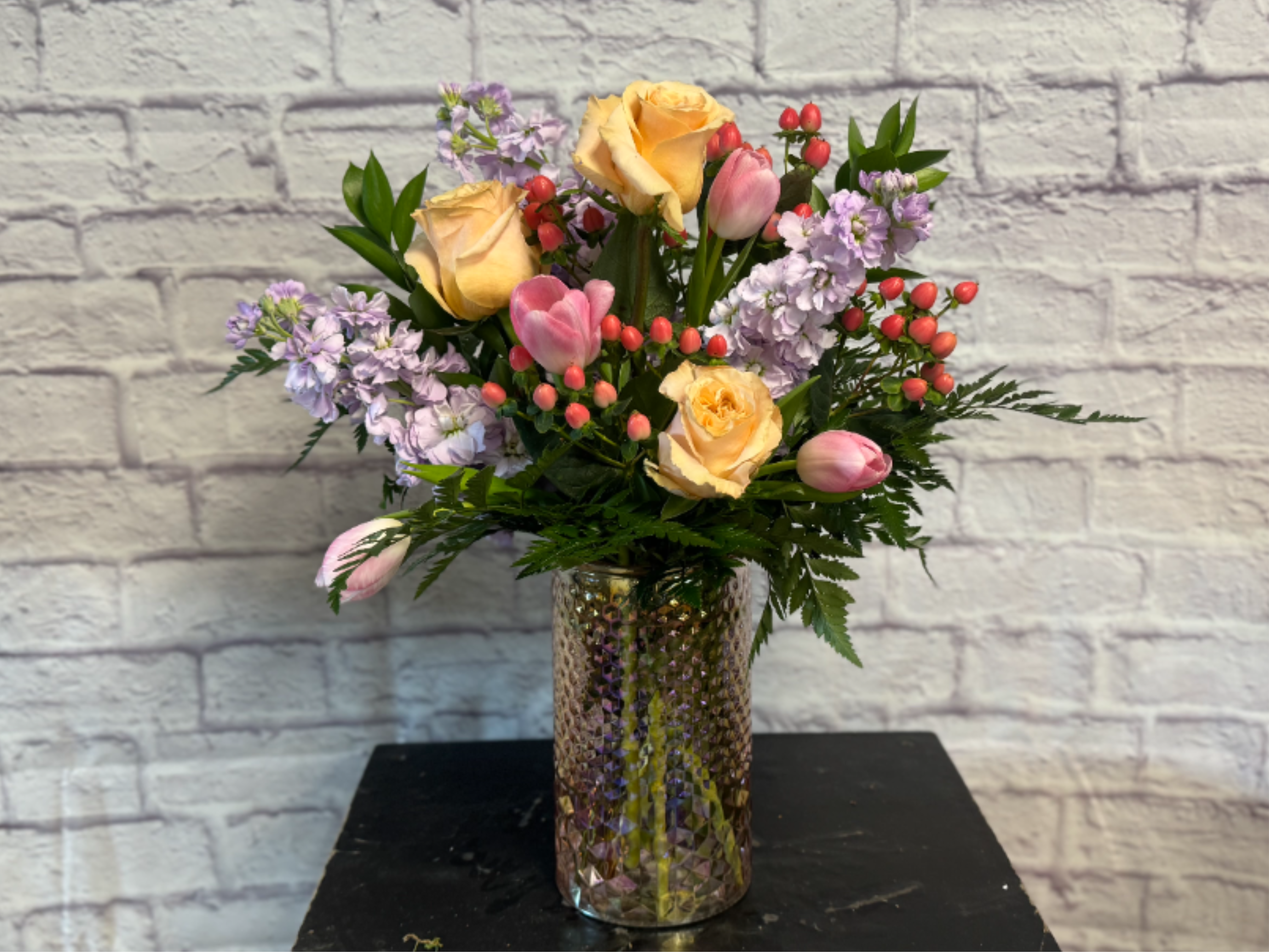 Spring Radiance - Beautiful array of Shimmer roses, delicate stock, pink tulips and a heart full of love in a stunning pink iridescent vessel.