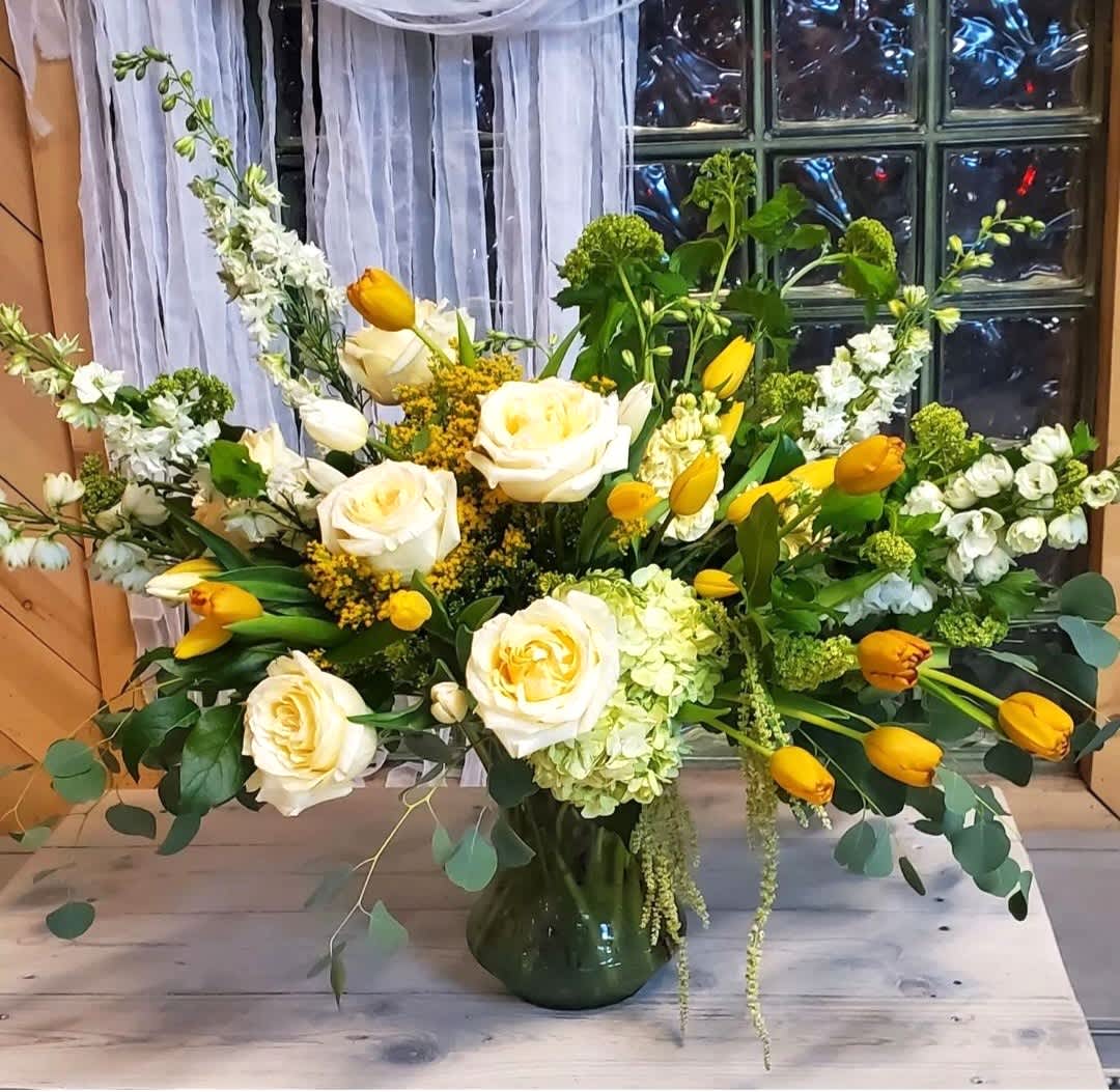 Elegant Sunshine - This stunning arrangement made with oversized butter yellow roses and an abundant amount of tulips will make anyone's day a whole lot brighter.