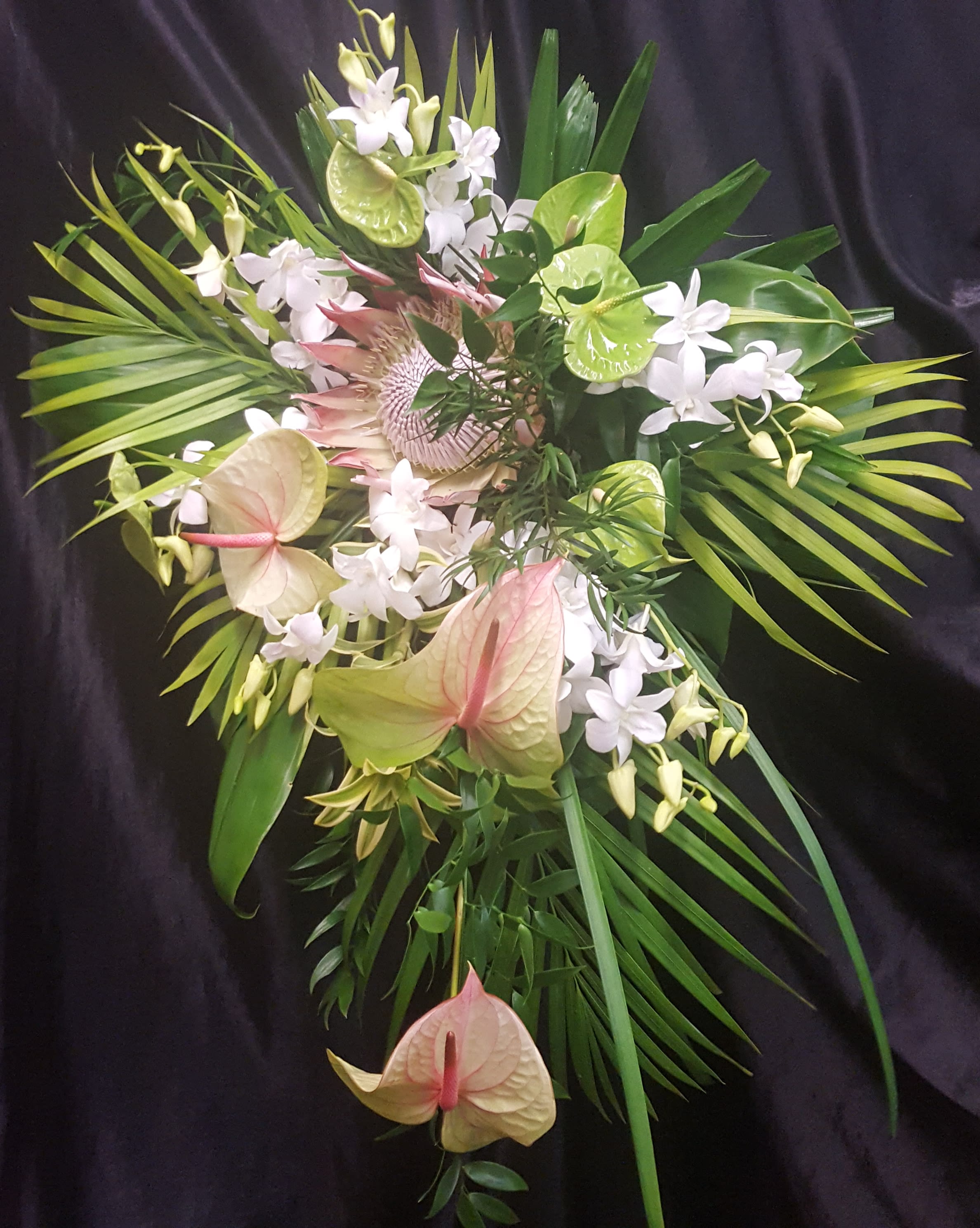UNSTRUCTURED TROPICAL CLUTCH BRIDAL #3 - KING PROTEA, ANTHURIUMS, DENDROBIUM ORCHIDS, ARECA PALMS, DRACENA, LILLY GRASS. SIZE 20" X 30"