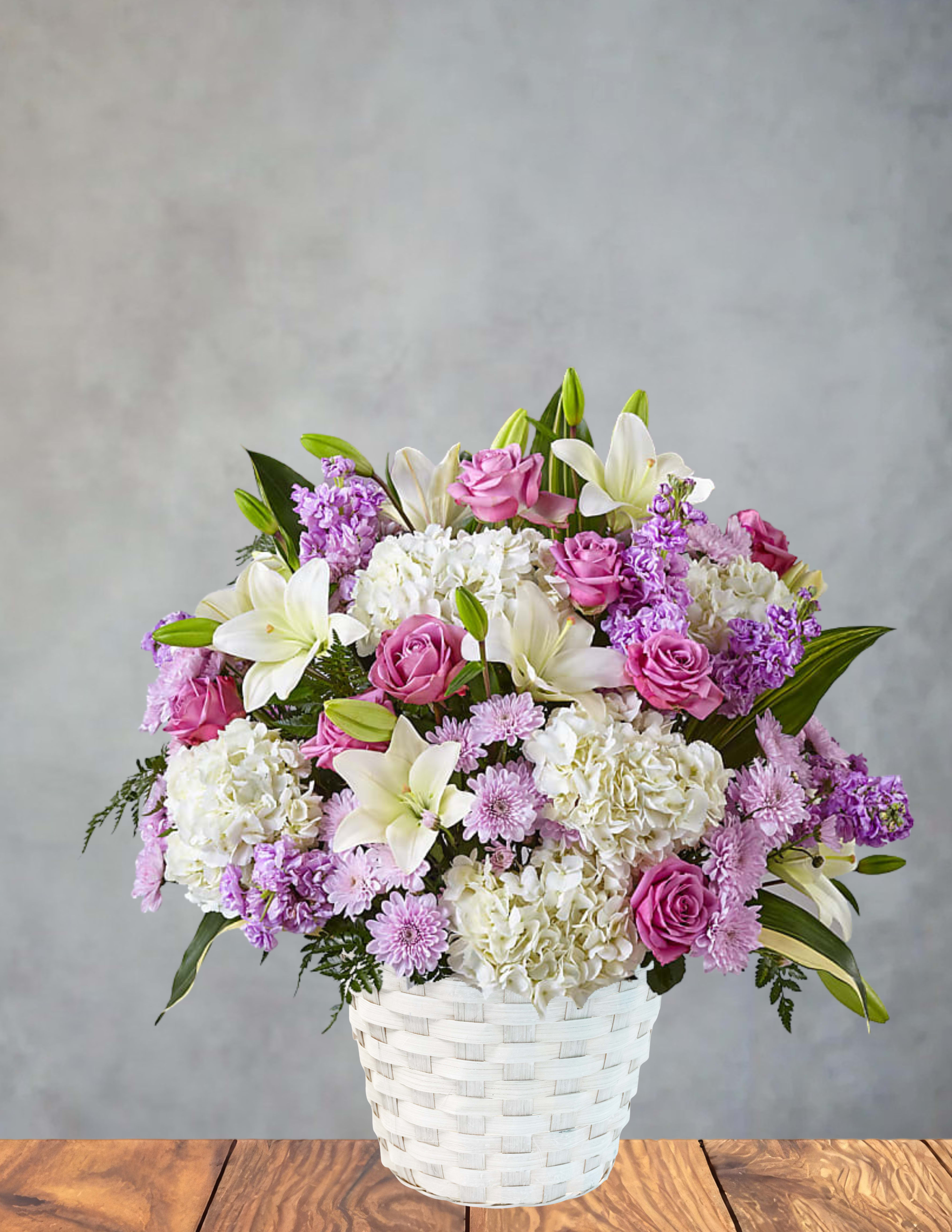 Lavender and lace  - A whisper‑soft blend of elegance and charm, Lavender &amp; Lace brings together dreamy pastels and lush textures in a woven white basket. Creamy hydrangeas, blush roses, and lavender chrysanthemums mingle with fragrant stock and graceful lilies, creating a garden‑fresh harmony that feels both timeless and tender. Gentle greenery adds movement and depth, giving the arrangement a natural, effortless beauty.  Perfect for celebrating love, offering comfort, or brightening any space with a touch of refined serenity.