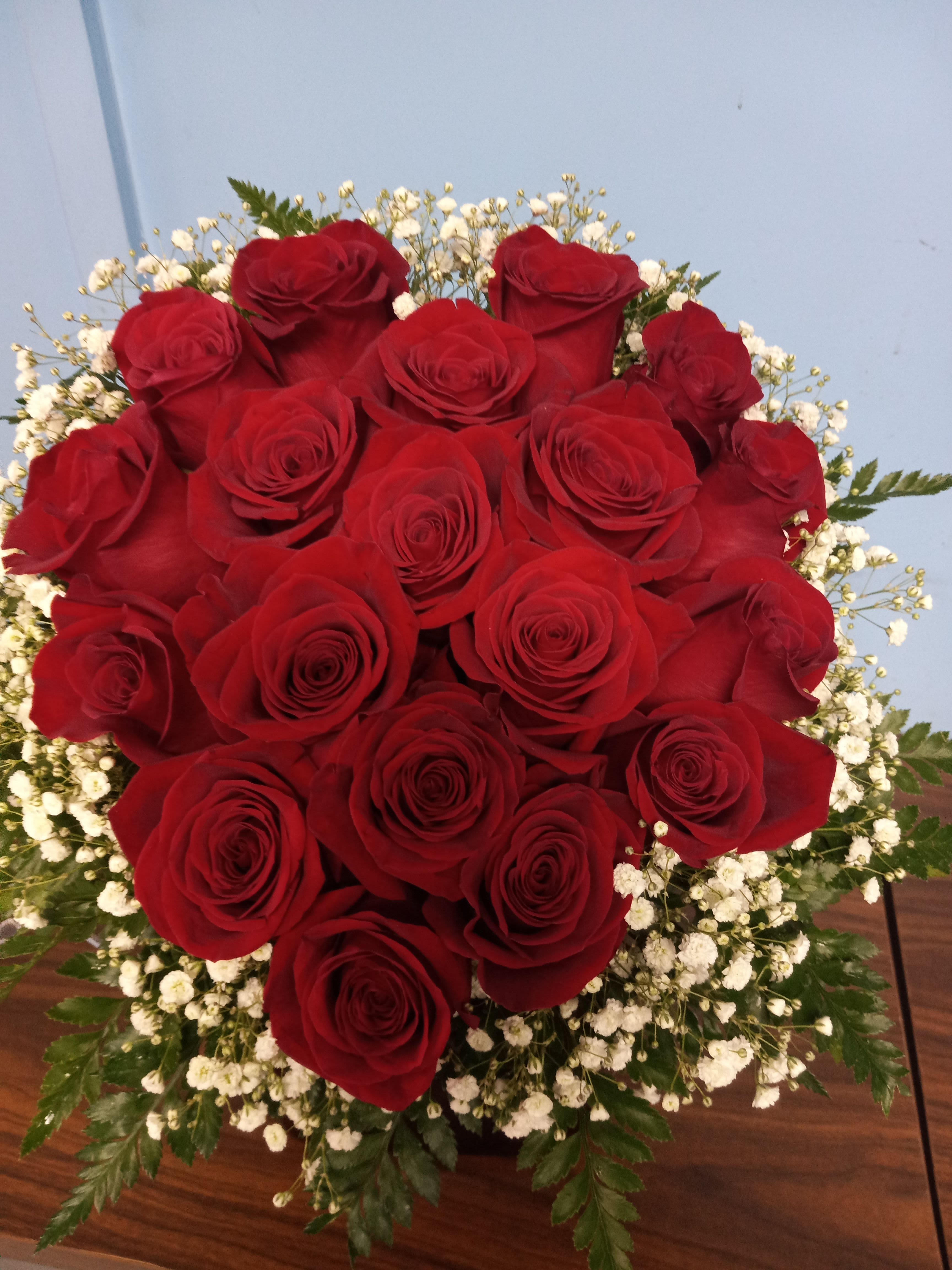 Heartbeat  - premium red roses artistically designed in a heart shape in a red vase outlined in baby's breath. 