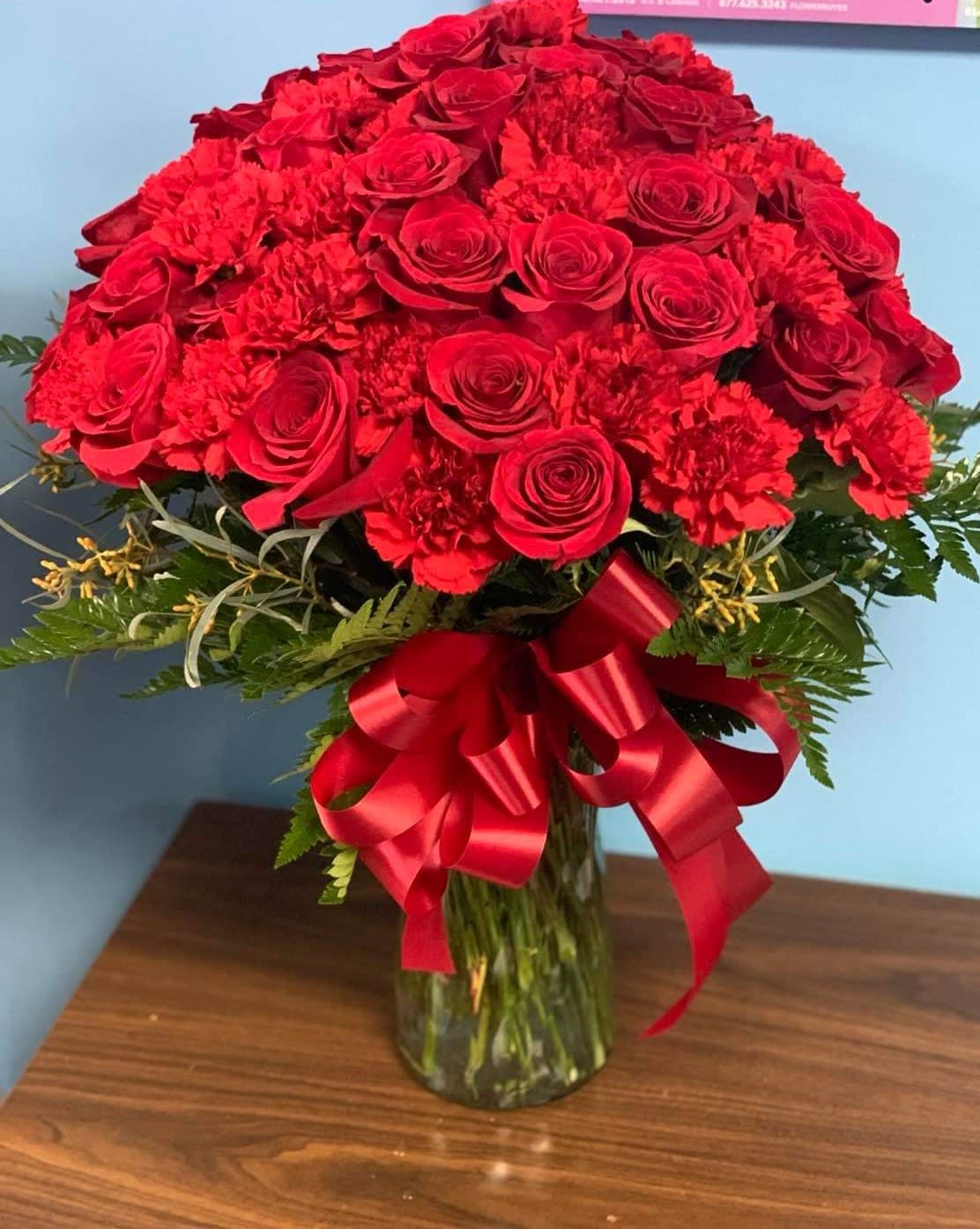 Red Wave Bouquet  - Two dozen red roses and two dozen red carnations in a glass vase 