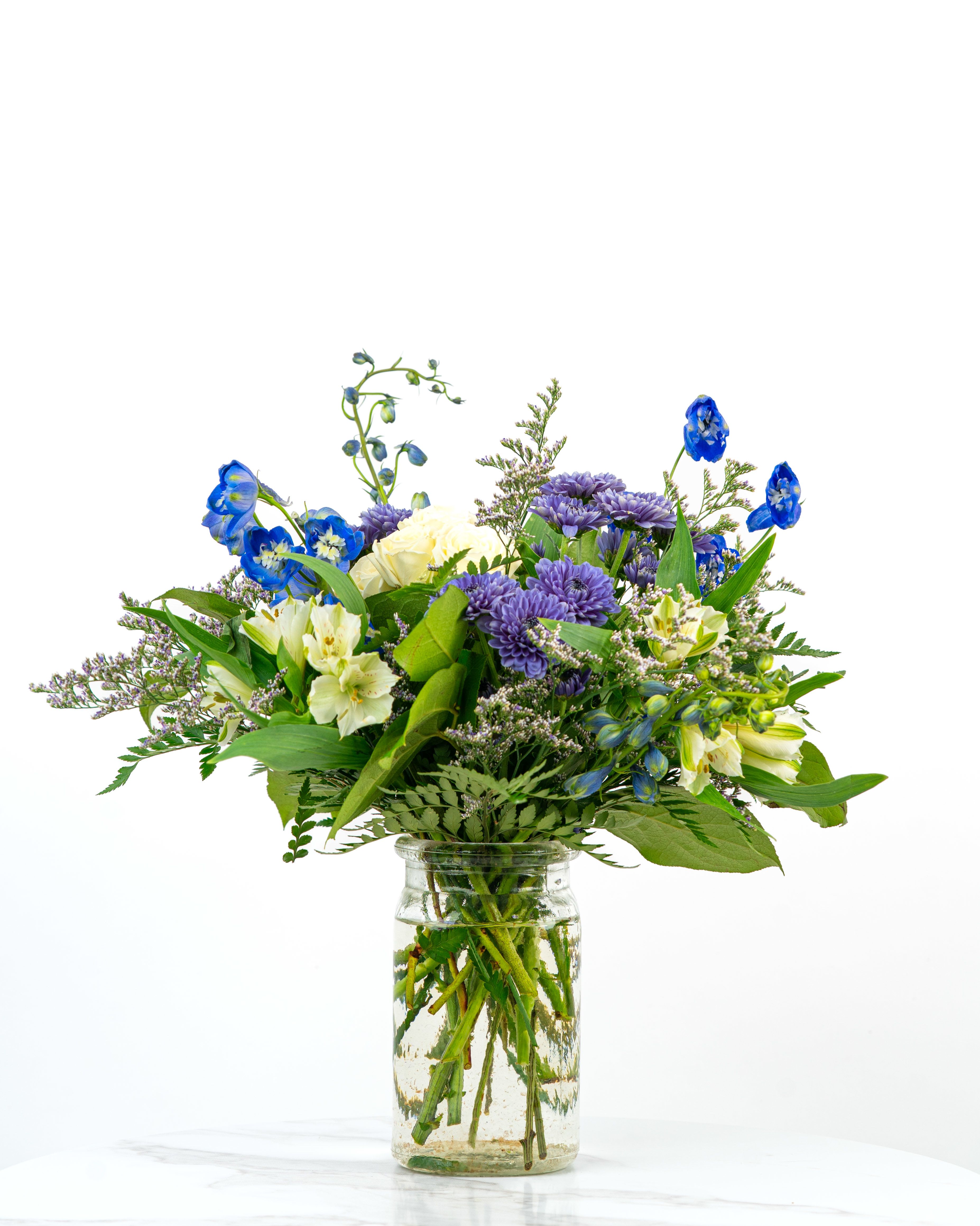 Our Gentle Thoughts Collection: White &amp; Blue Blooms - Let our floral designers express your support, sympathy, love, and more with an arrangement in serene white and blue blooms from our Gentle Thoughts Collection. At Schultz Floral, each arrangement is one of a kind and styled just for your order. Because we always use the freshest blooms, your final arrangement may not look exactly as pictured due to bloom variation and availability. Rather, our Gentle Thoughts Collection is intended to celebrate positivity and peace.