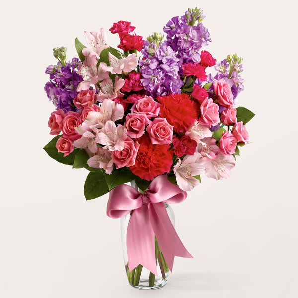 Main Character Bouquet - A sophisticated blend of classic elegance and rich fragrance. Featuring red carnations and delicate pink spray roses nestled against purple stock. Perfect for those who appreciate a textured, garden-style look with a sweet scent.