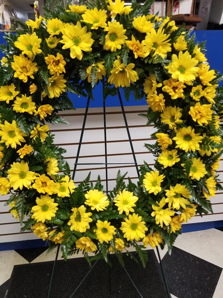 Sunshine of Hope Wreath - A wreath filled with daisies and greenery