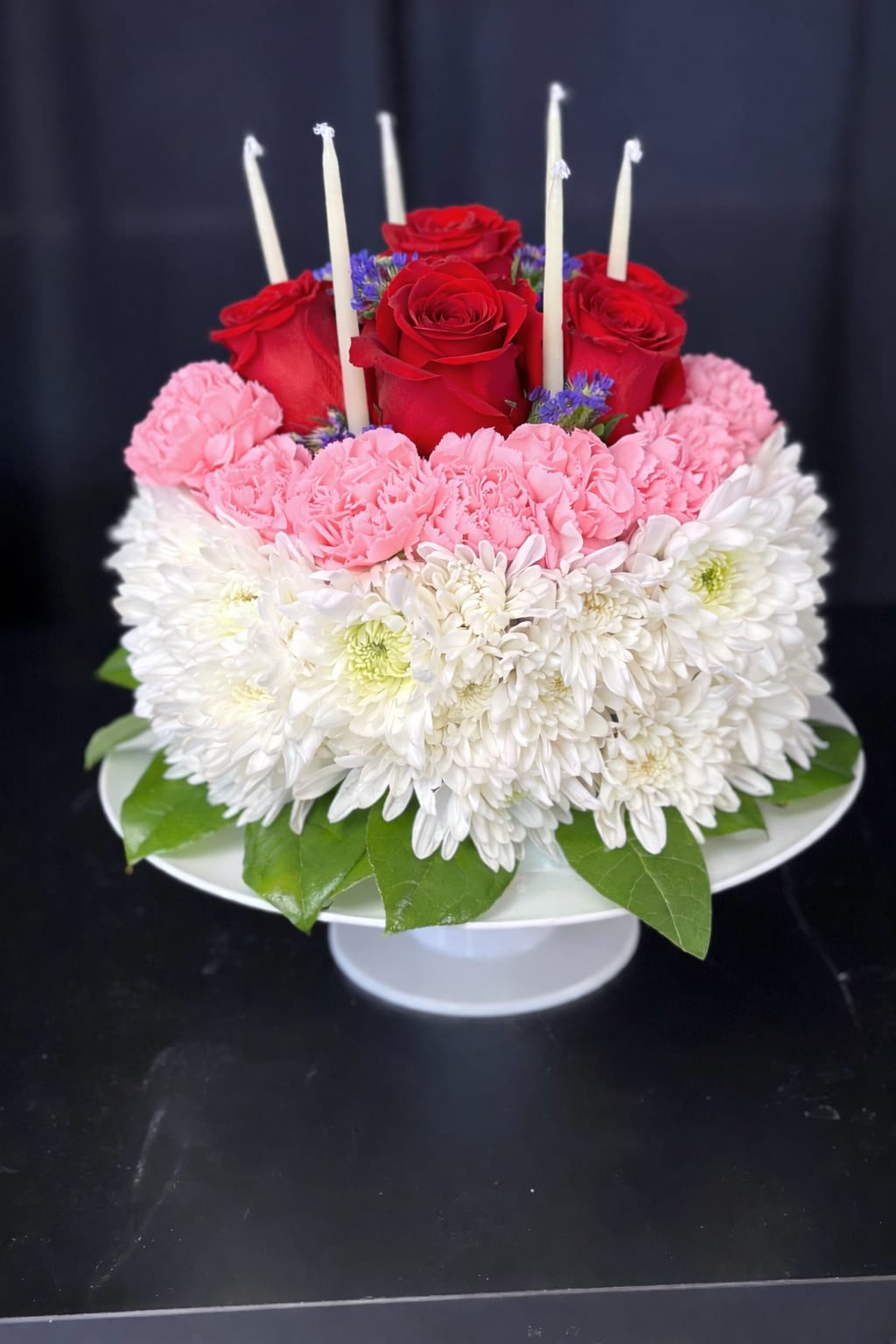 Its My Party! - Celebrate in style with our Happy Birthday floral "cake," adorned with vibrant blooms and topped with flickering candles! This whimsical creation captures the essence of joy and festivity, perfect for marking the special occasion of a loved one's birthday. Each petal is a sweet wish, and each candle a beacon of celebration, making this floral arrangement a delightful centerpiece for the festivities.