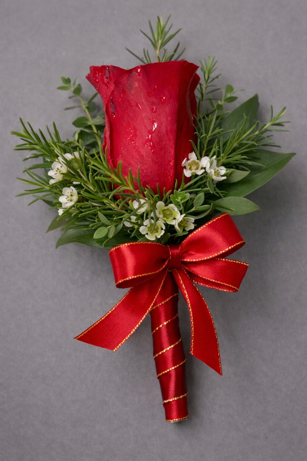 Red Rose Boutonnière - A  finishing touch for a wedding or prom. Consisting of a carefully selected red rose complemented with baby’s-breath and greenery, It comes with ribbon of your choice of colors: black, gold, light blue, light pink, purple, silver, or white if the color you desire is not listed please give us a call or write in in "delivery notes" at checkout anyways. If we do not have it we will contact you.    If no ribbon color is mentioned in "delivery notes" at checkout we will make the ribbon red like shown in photo. 