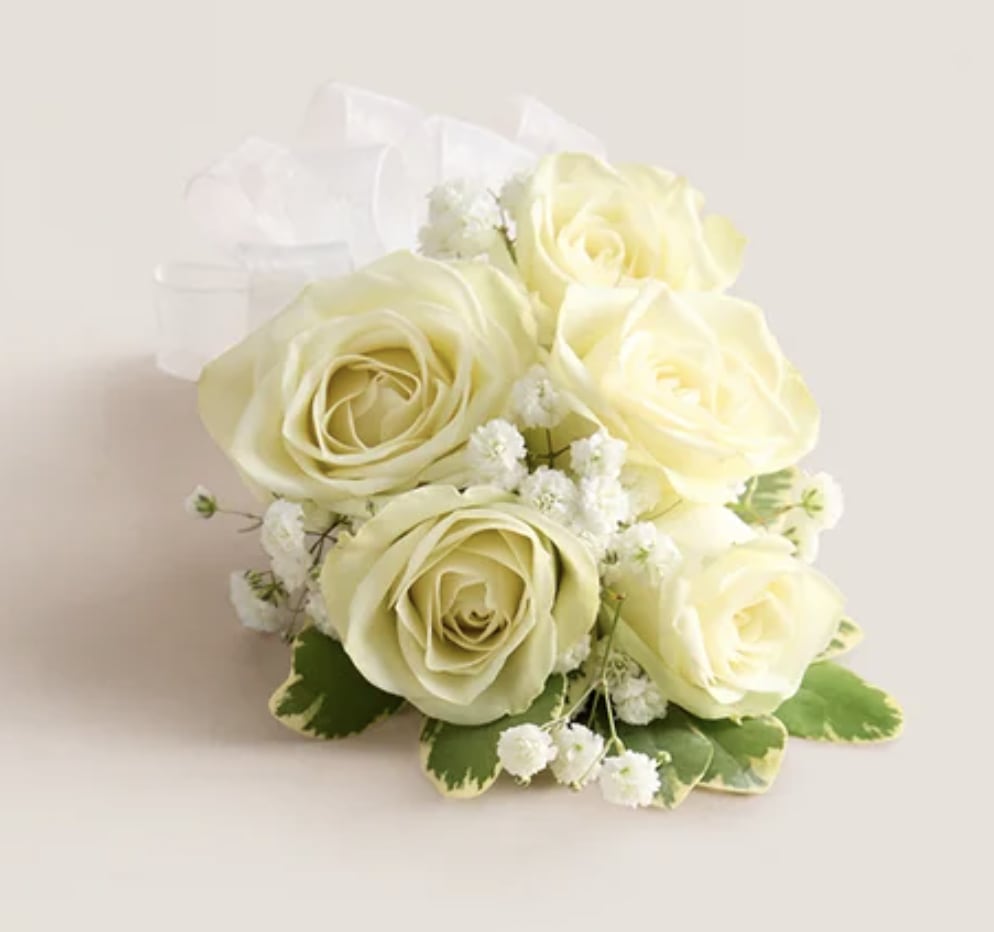 White Rose Corsage - A  finishing touch to a wedding gown, a prom dress, or any other special-occasion finery. Consisting of carefully selected white spray roses complemented with baby’s-breath and greenery, our corsage comes with ribbon in your choice of colors: black, gold, light blue, light pink, purple, silver, or white. If the color ribbon you desire is not listed please give us a call or write in in "delivery notes" at checkout anyways. If we do not have it we will contact you.    If no ribbon color is mentioned in "delivery notes" at checkout we will make the ribbon white like shown in photo. 
