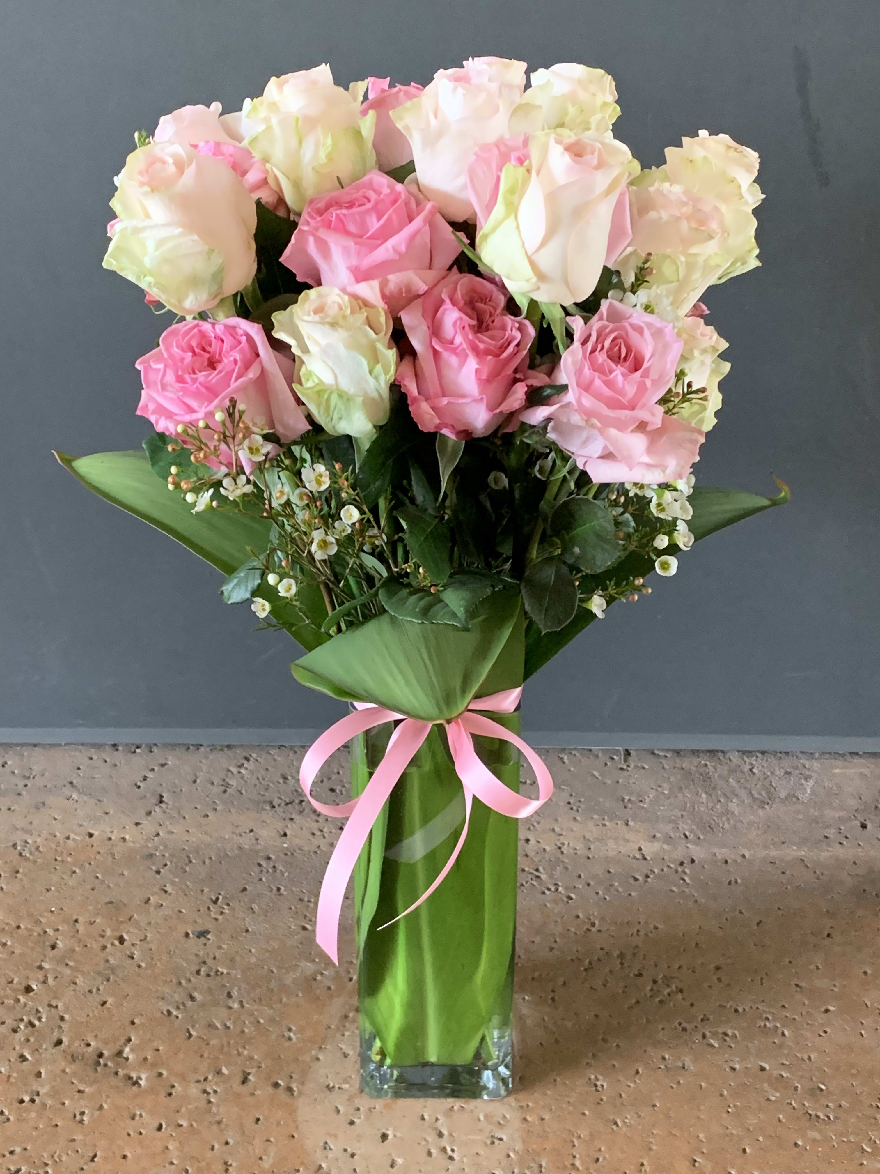 Two Dozen Pink - A beautiful mixture of shades of pink roses arranged in a tall square glass vase.