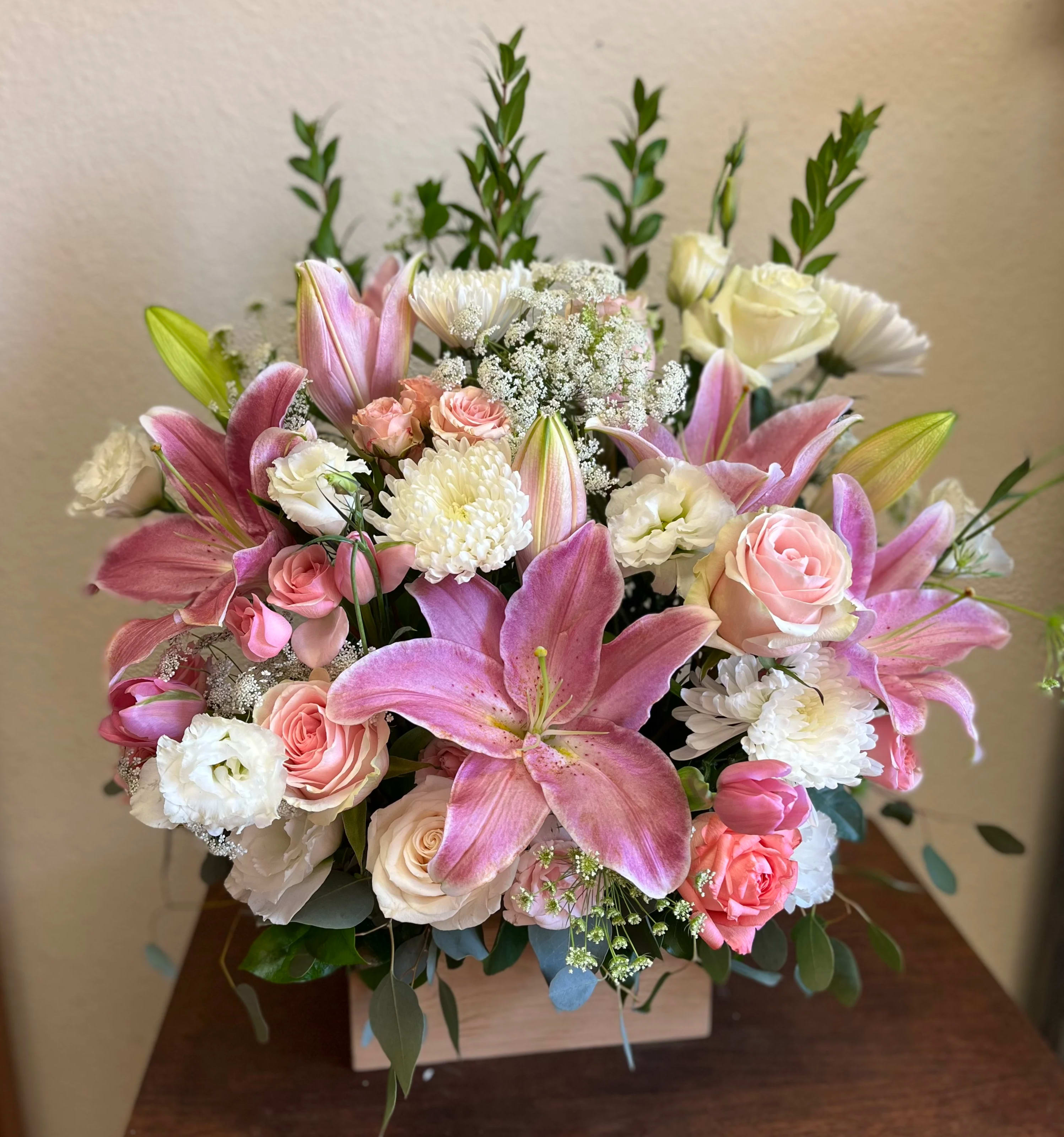 Love and Harmony - Recipe: Pink Stargazers, Roses, Lisianthus, Chrysanthemums, Spray Roses and Tulips in a local, handmade wooden box. Availability: All year round Design View: Symmetric Front Facing View Photo shown: Regular
