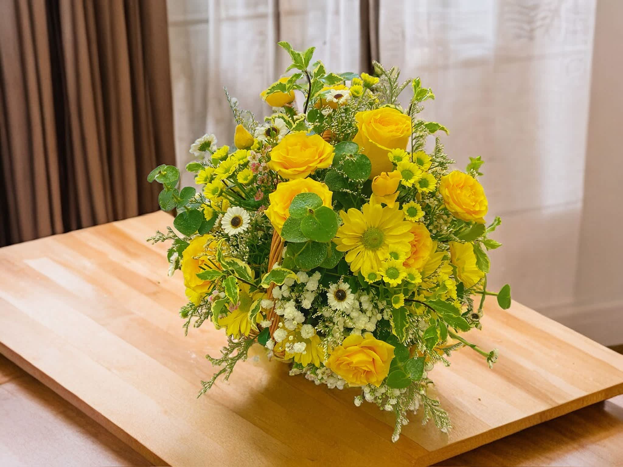 Happiness  - This medium design includes a variety of flowers (roses, spray roses and  seasonal foliage, nestled in a basket.  All flowers are subject to availability