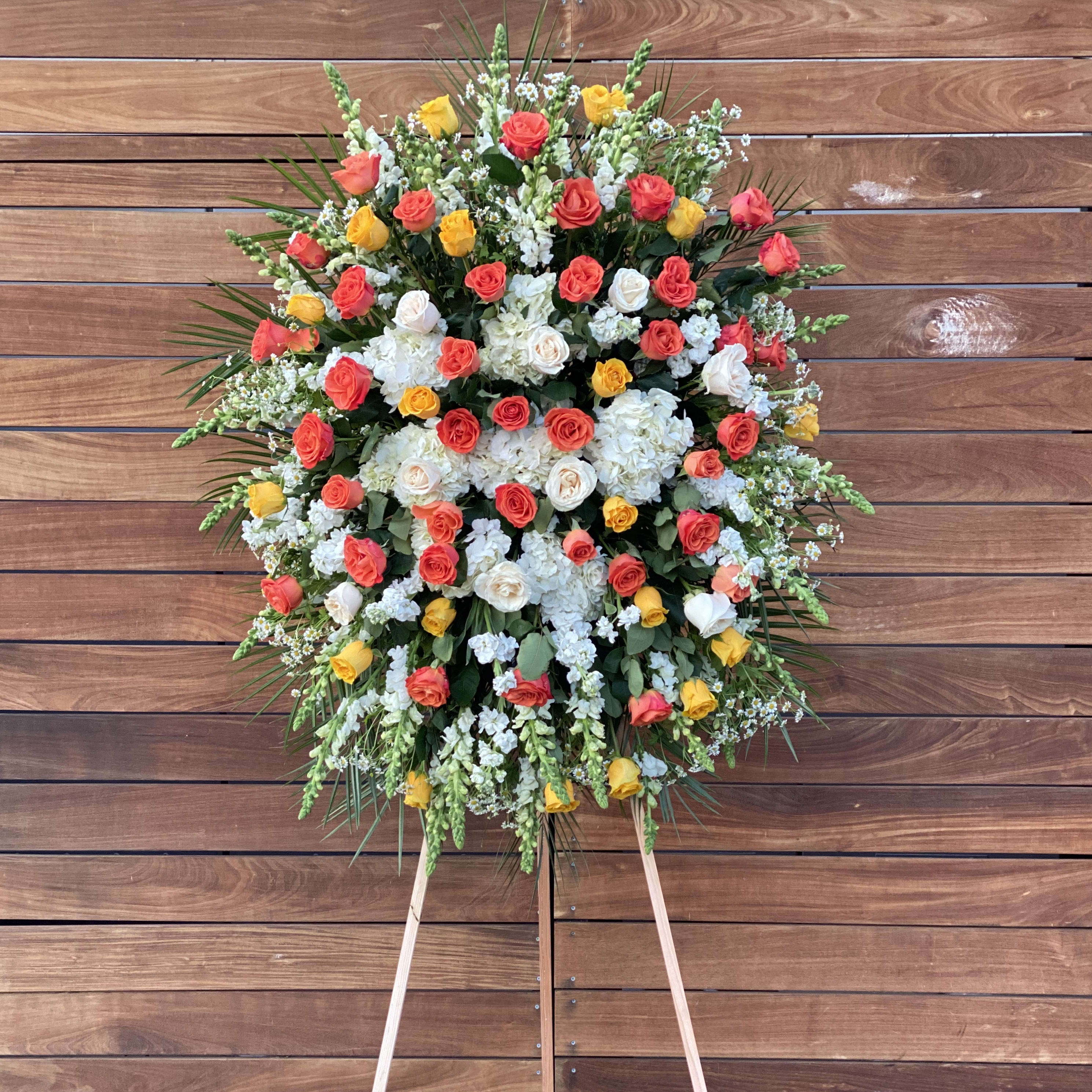Forever Loved - Sympathy easel arrangement with white hydrangeas and different colored roses and additional greenery.