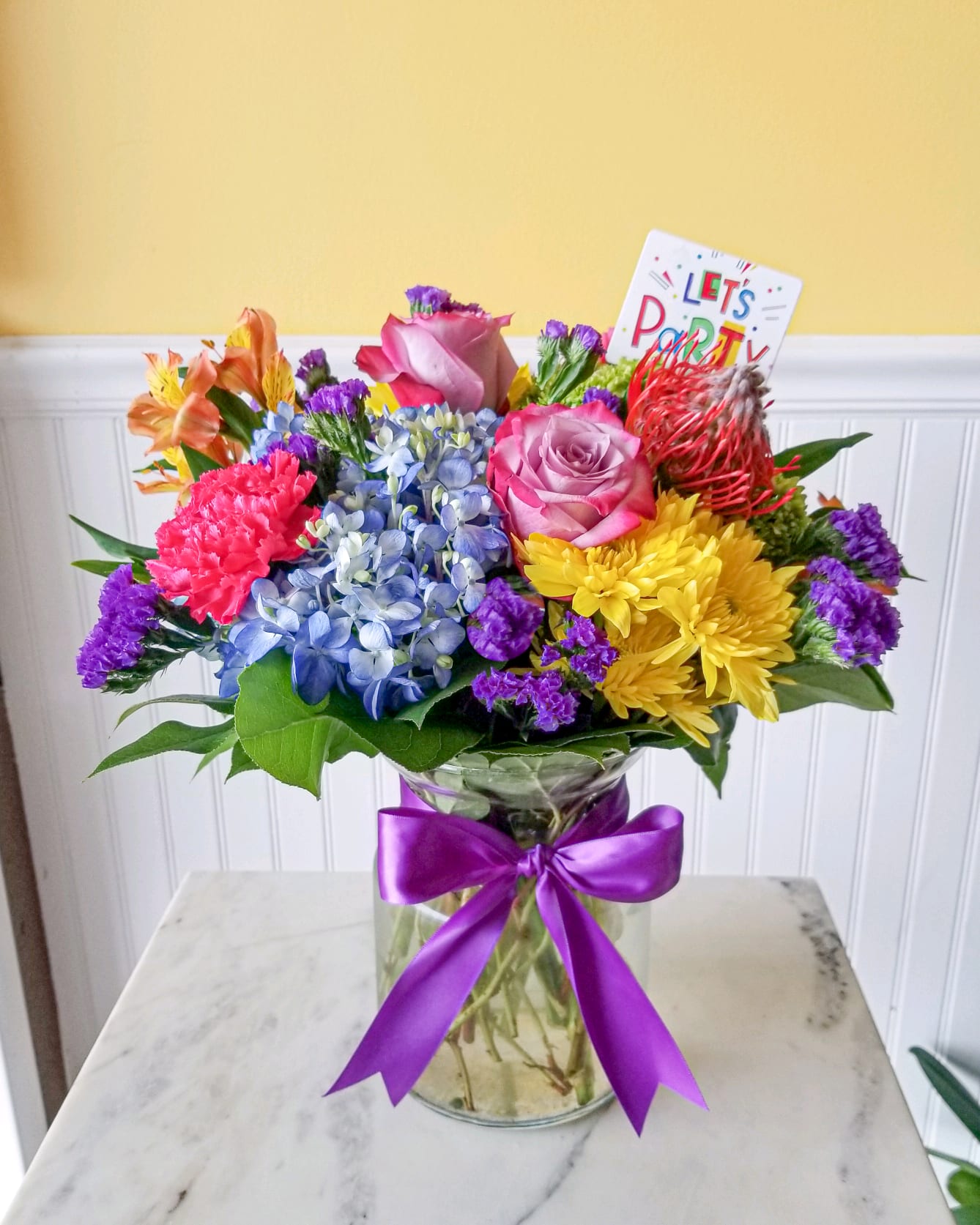 Birthday Blast - Wish someone you love with this Happy Birthday Floral arrangement.  This bold &amp; beautiful bouquet full of vibrant colors! You'll brighten their day in more ways than you'll know as they sit and admire this wonderful gift.  approx dimensions : 12 in W X 16 in tall