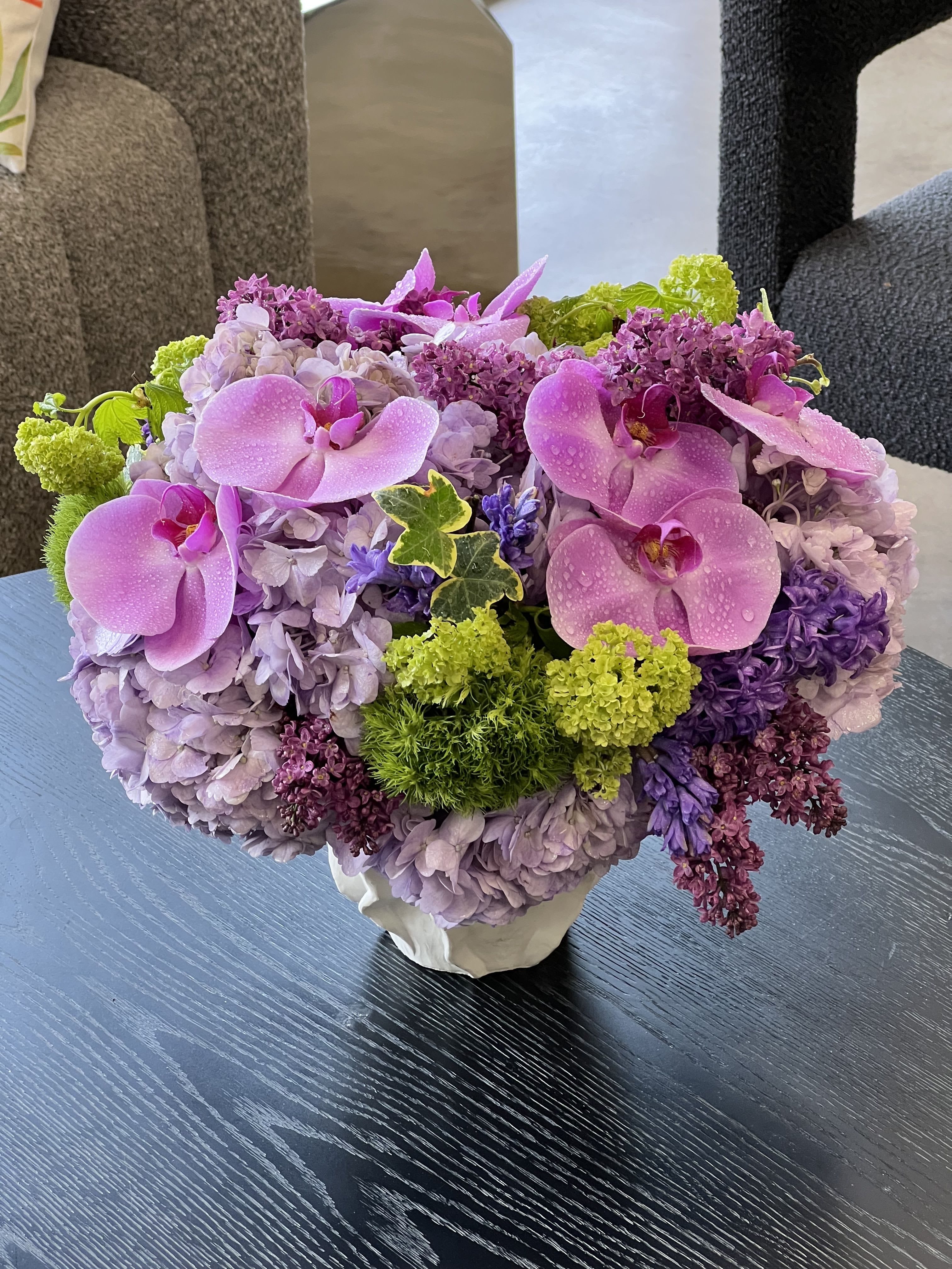 Roma  - A gorgeous assortment of blooms, including Phalaenopsis Orchids, Lilac, Hyacinth, Hydrangea, and mixed greens