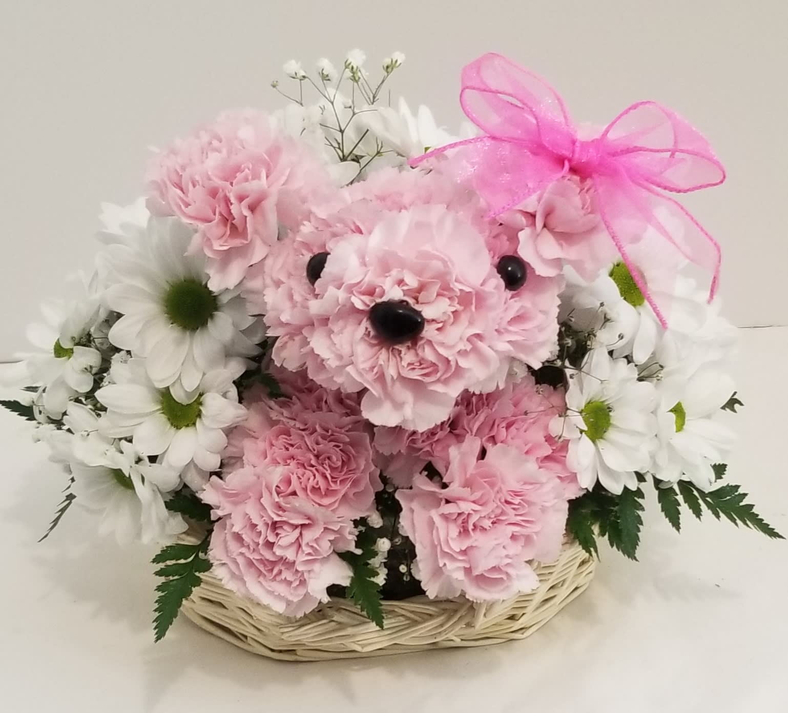 Pretty in Pink Pup - Add a little princess power to her day with our perfectly pink  pup arrangement. Hand-designed by FlowerBee floral artisans using fresh pink carnations, daisy/poms and more, she arrives in a cute basket accented with beautiful pink ribbon to make sending smiles to your princess a true walk in the park.  The freshest flowers are selected so components may vary (we will maintain the color scheme of pink and white)