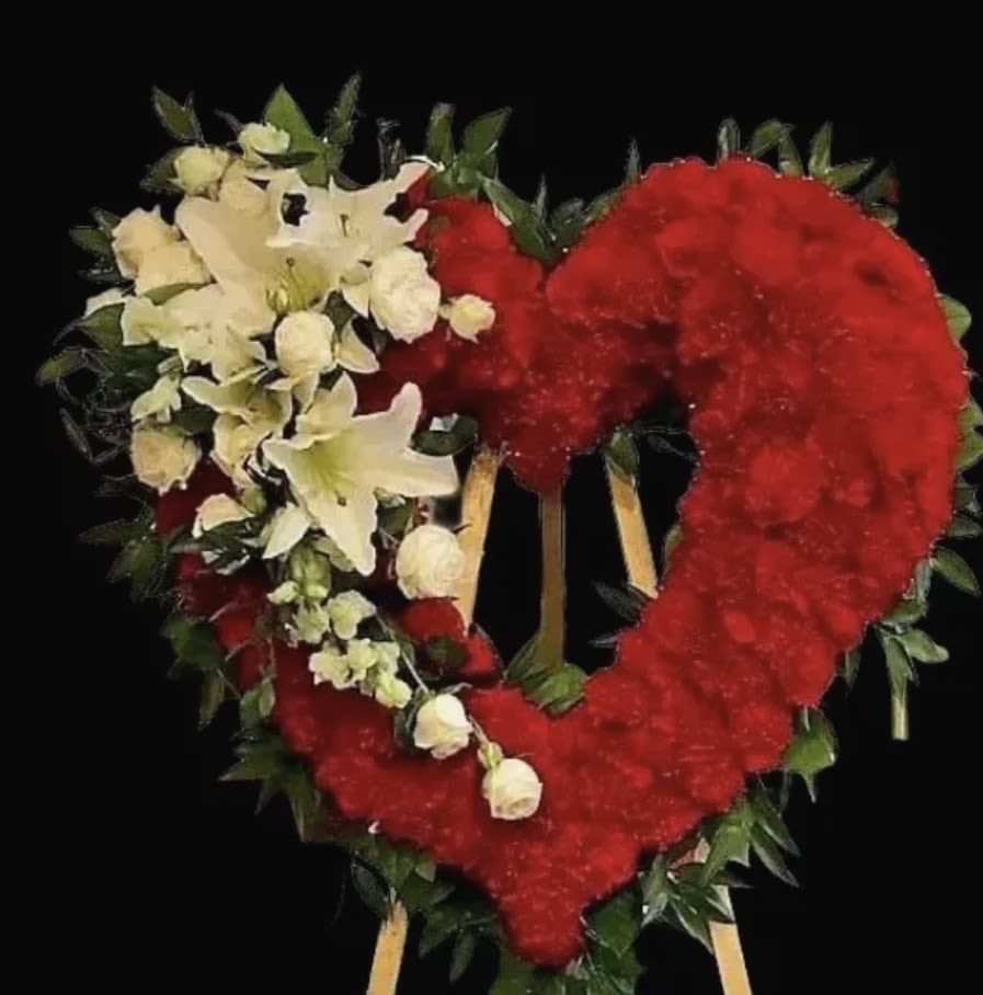 FOREVER MY HEART - A six foot tall open heart design consisting of 175 plus stems of red carnations. Followed by a cascading correspondence of white lilies, white dendrobium orchids and corresponding filler and greens to amplify this stunning sympathy design.