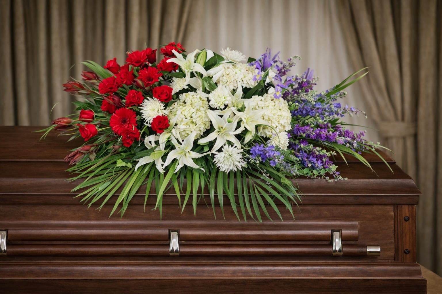Unity Casket Spray  - Vibrant red, white, and blue flowers beautifully arranged in a floral casket spray.  A unique arrangement hand created by our experienced designers. Please note that every design is custom made and substitution to container and flower types may happen from time to time. Design aspects will always stay the same, but if needed, we will substitute with flowers of equal or greater value to offer you a great floral shopping experience! Our flowers are 100% guaranteed. Please call us with any questions or concerns.