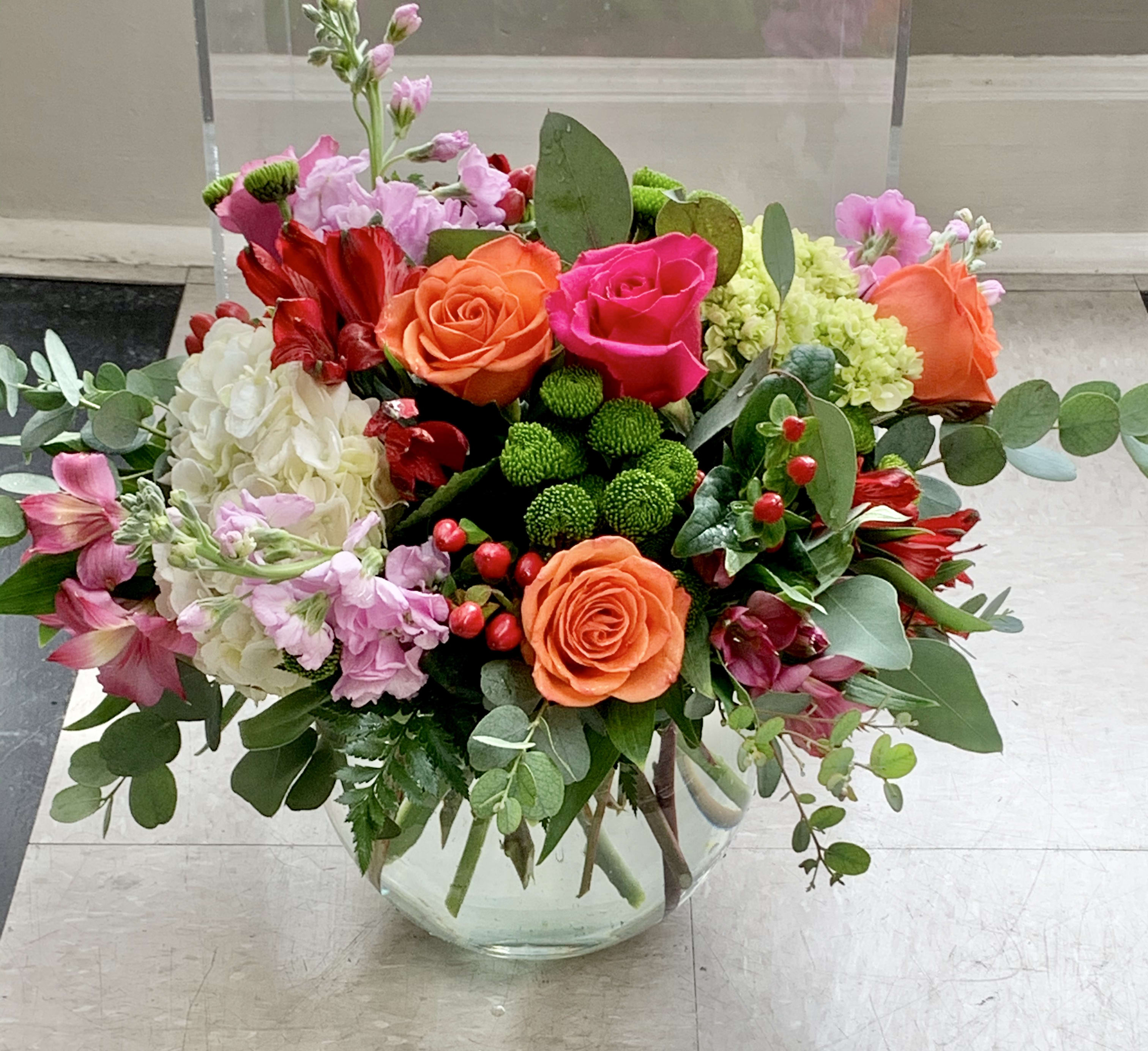 Garden Inn - This arrangement includes hot pink and orange Roses, green, white,blue, or green Hydrangeas, green Dianthus or green Buttons, Dusty Miller or Eucalyptus, Alstroemeria, and Stock. This Garden is the perfect gift to wish someone a happy birthday or to say thank you.  