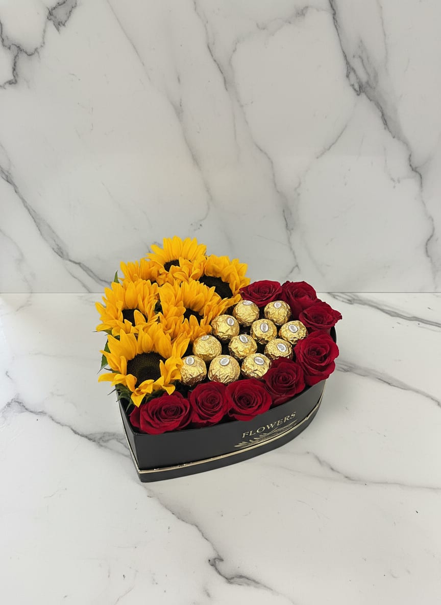 Sunny chocolate Heart box  - Our Sunny Choco Heart Box is a unique arrangement that blends warmth and romance. One half of the heart box is filled with bright sunflowers, while the outer right side features classic red roses paired with Ferrero Rocher chocolates