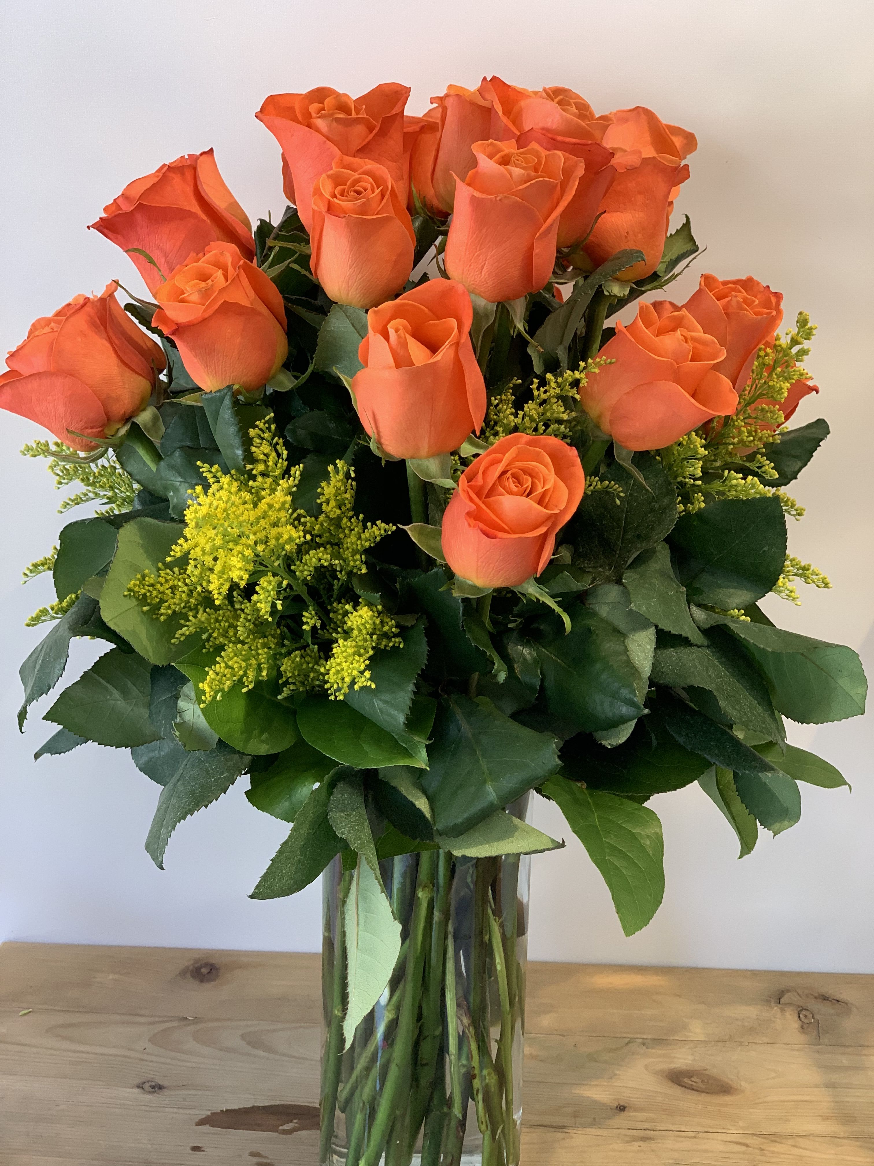 Solar Flare | Dozen Long Stem Orange Roses | Professional Orange Rose Delivery in San Francisco - Experience the vibrant warmth of the Bay Area with our 12-stem orange Rose collection. As a dedicated San Francisco florist, Fillmore Florist leverages our proximity to the local flower market to ensure every bloom in your San Francisco flower delivery is at its peak physiological state. This striking, year-round arrangement is engineered to command attention and radiate joy.  Meticulously composed in a classic glass vase, this design features:      12 Premium Long-Stem Orange Roses: Hand-selected for their saturated color and architectural height.      Textured Solid Asters: Providing a rhythmic, golden-yellow contrast.      Lemon Leaf Greens: For a clean, waxy frame that highlights the rose heads.  The Fillmore Florist Strategic Advantage      Market-Fresh Proof: We visit the local market daily to hand-pick these specific long-stem varieties. This allows us to ensure quality for your flower delivery in San Francisco, guaranteeing a vase-life that national shippers cannot match.      Master Designer Integrity: Our San Francisco flower delivery is never automated. Every vase is hand-styled by our master designers to ensure 360-degree balance and freshness.      Verified Front-Door Logistics: We take pride in being your trusted San Francisco florist. We manage the entire delivery chain, ensuring these bright, striking flowers arrive in showroom condition.  Experience Flower delivery in San Francisco by Fillmore Florist in San Francisco.   Approximate Dimensions: 17" H x 12" W