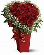 Heartfelt Romance Rose Arrangement - Sweep your Valentine off their feet with the Heartfelt Romance Rose Arrangement, a breathtaking symbol of love and devotion. This stunning bouquet features luxurious red roses, artfully arranged in the shape of a heart, surrounded by delicate baby’s breath and accented with fresh greenery. The arrangement is presented in an elegant red vase with charming "XOXO" ribbon details, perfectly capturing the spirit of romance.  Ideal for expressing deep affection, whether it's for a partner, spouse, or secret admirer, this arrangement is more than just flowers—it's a heartfelt declaration of love.  Why It’s Perfect for Valentine’s Day: ️ Heart-Shaped Design: A unique and romantic twist on the classic rose bouquet.  Premium Red Roses: The timeless symbol of passion and love.  Elegant Presentation: Complete with a red vase and playful "XOXO" ribbon, ready to impress.  Memorable Impact: A show-stopping centerpiece for Valentine’s Day celebrations.