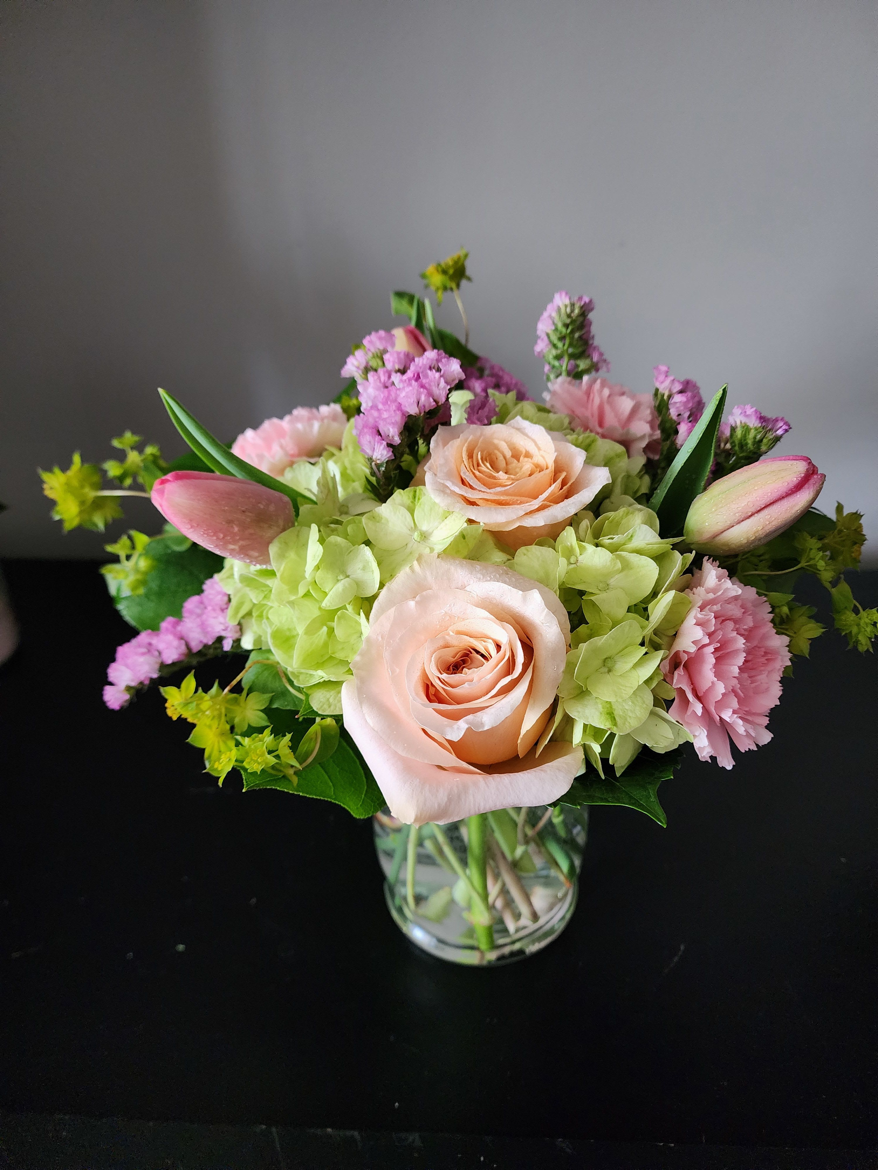 Spring Sorbet by MG Florist - Hydrangea, tulips, roses, statice, carnations, and a mixture of greenery arranged in a glass vase. Colors may vary depending on the avability.