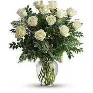 Dozen White roses - A classic dozen white roses, beautifully hand-designed by our floral team. White symbolizes purity, grace, and heartfelt sincerity! Designed in a glass vase with greenery and filler, these premium long-stemmed roses are pure elegance!