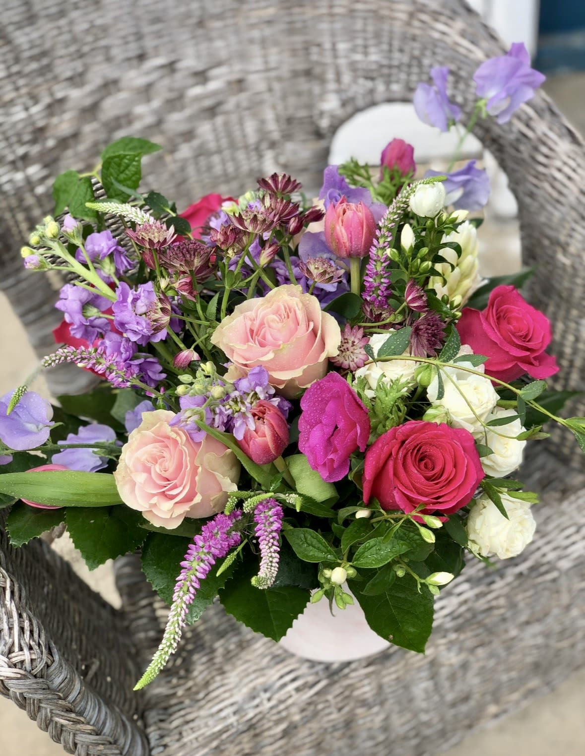 SEASONAL SHOWSTOPPER  - A gorgeous combination is in season, bright, happy blooms. We offer roses, Veronica, heloboris, tulips, and many other  seasonal flowers. This one comes designed in a 6x6 white container.