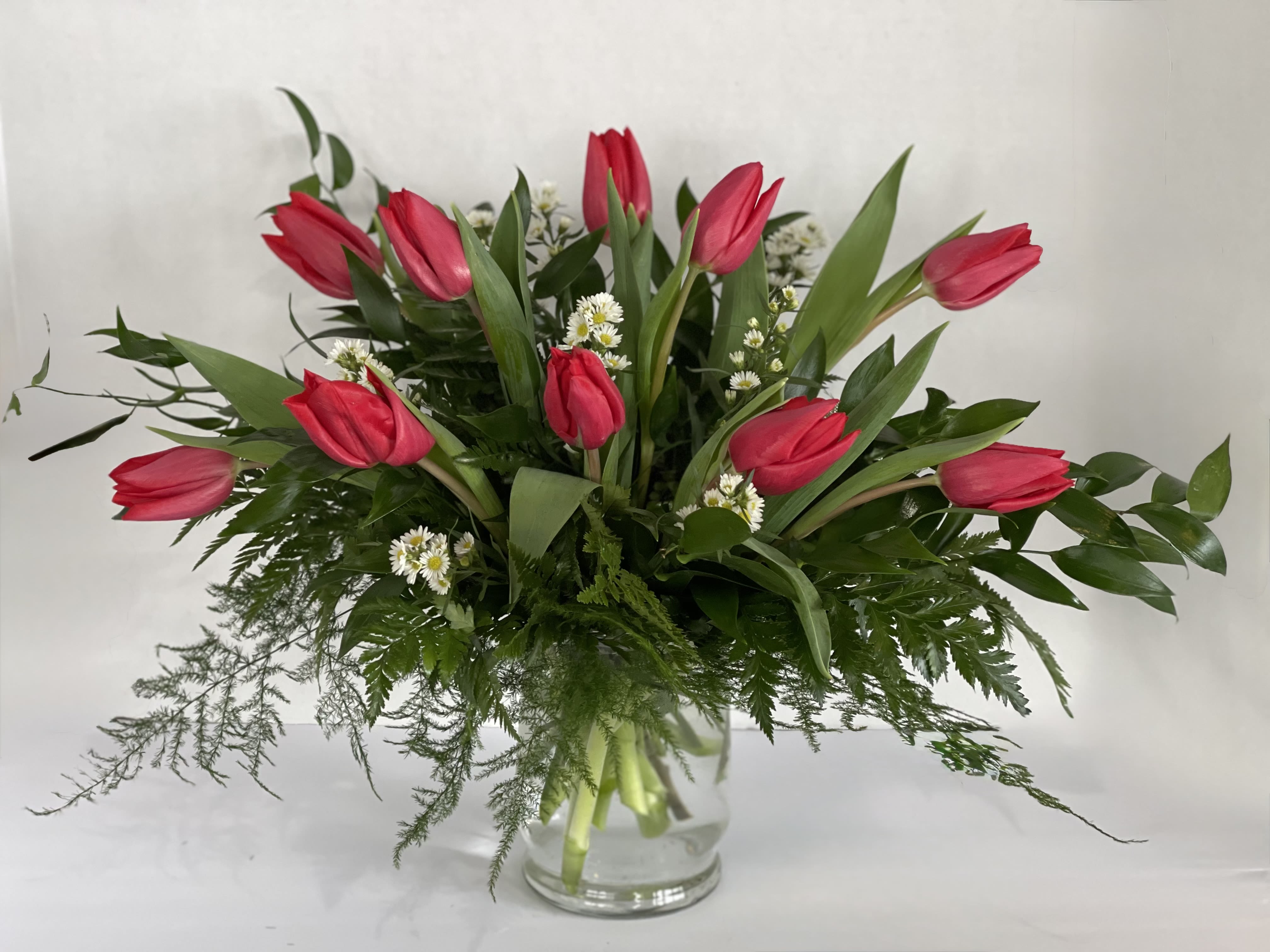 Beauty and Grace  - This elegant arrangement is made of tulips, accented with white asters, and adorned with premium greenery, including plumosa and Italian ruscus. Customize by requesting a special color of tulip! 