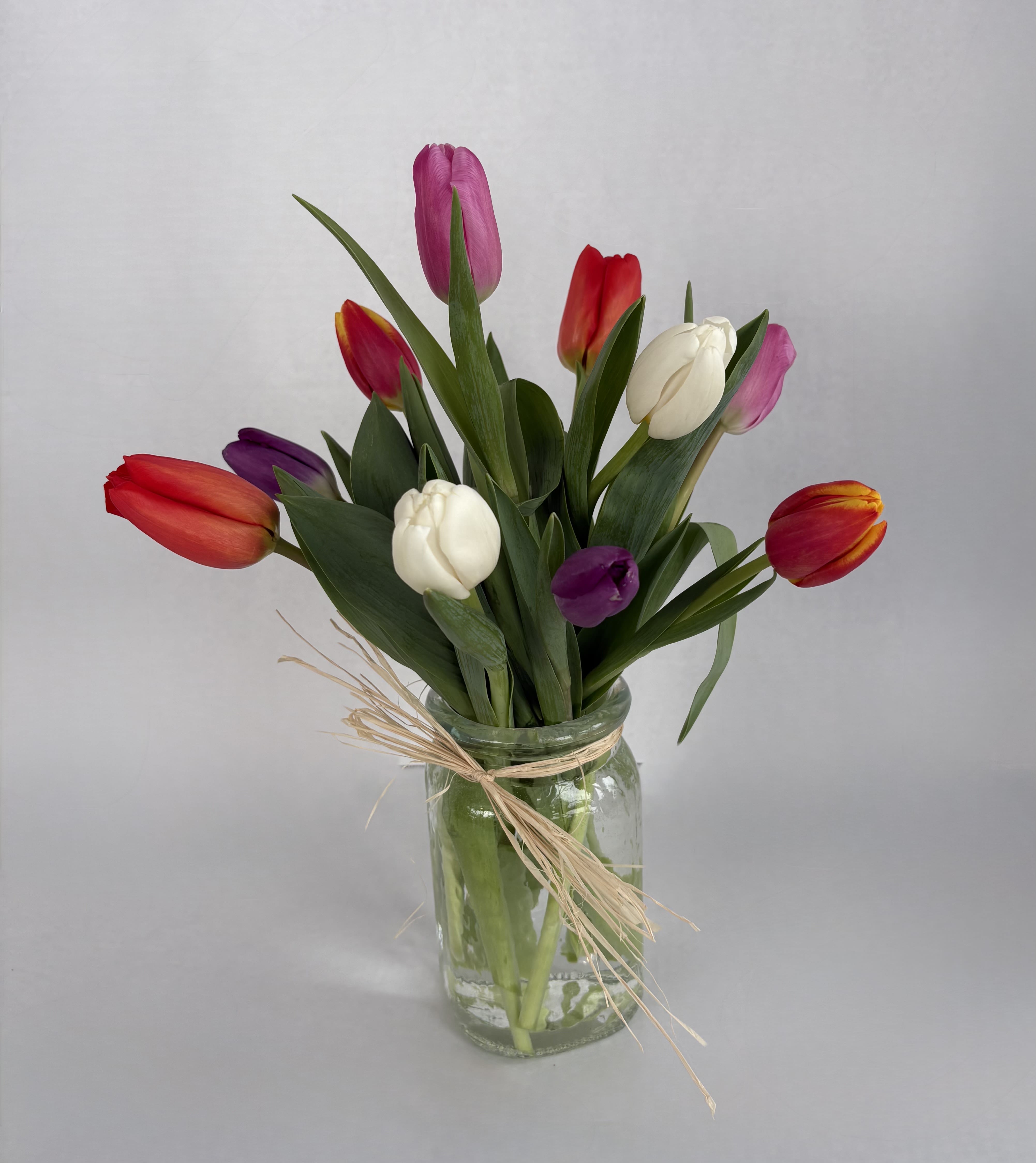 Touch of Tulips - An elegant arrangement for the Tulip Lover!  Our Touch of Tulips arrangement is designed by our fabulous design team and consists of single or multi-colored tulips in a clear mason jar. 
