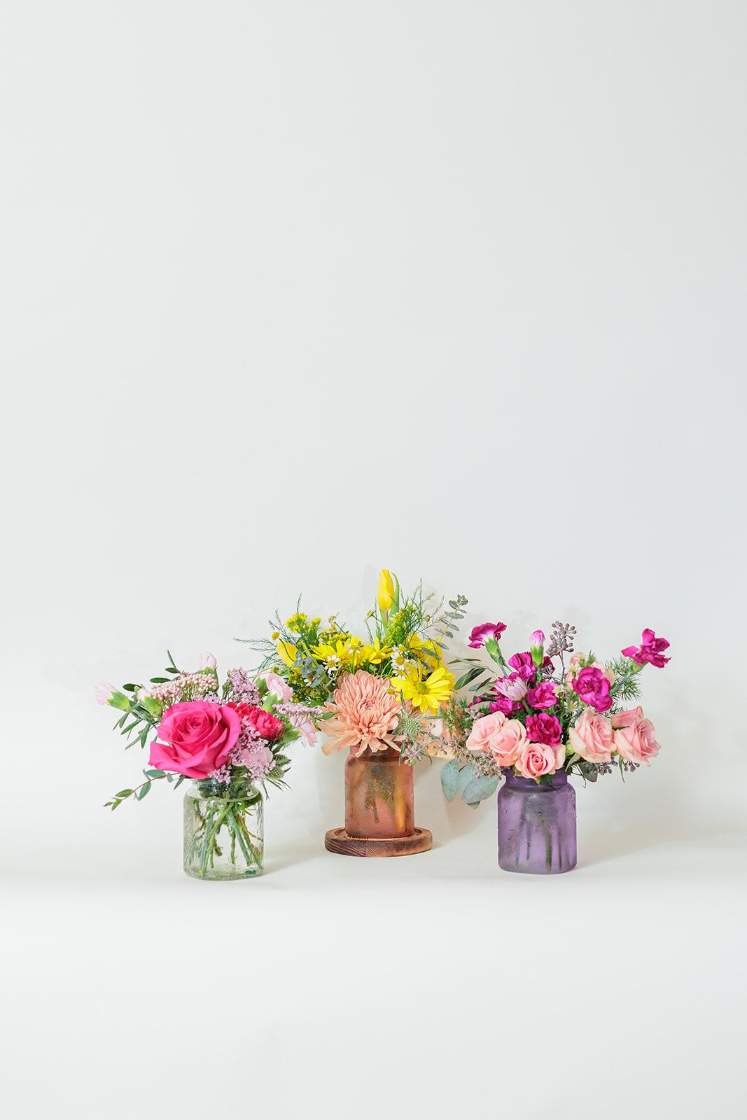 Mini Bundle Collection - Charming and versatile, this Mini Bundle Collection features 3 beautiful mini vases, each filled with a unique mix of vibrant blooms in different colors. Each mini vase is a beautiful work of art, offering a little burst of joy wherever it's displayed!