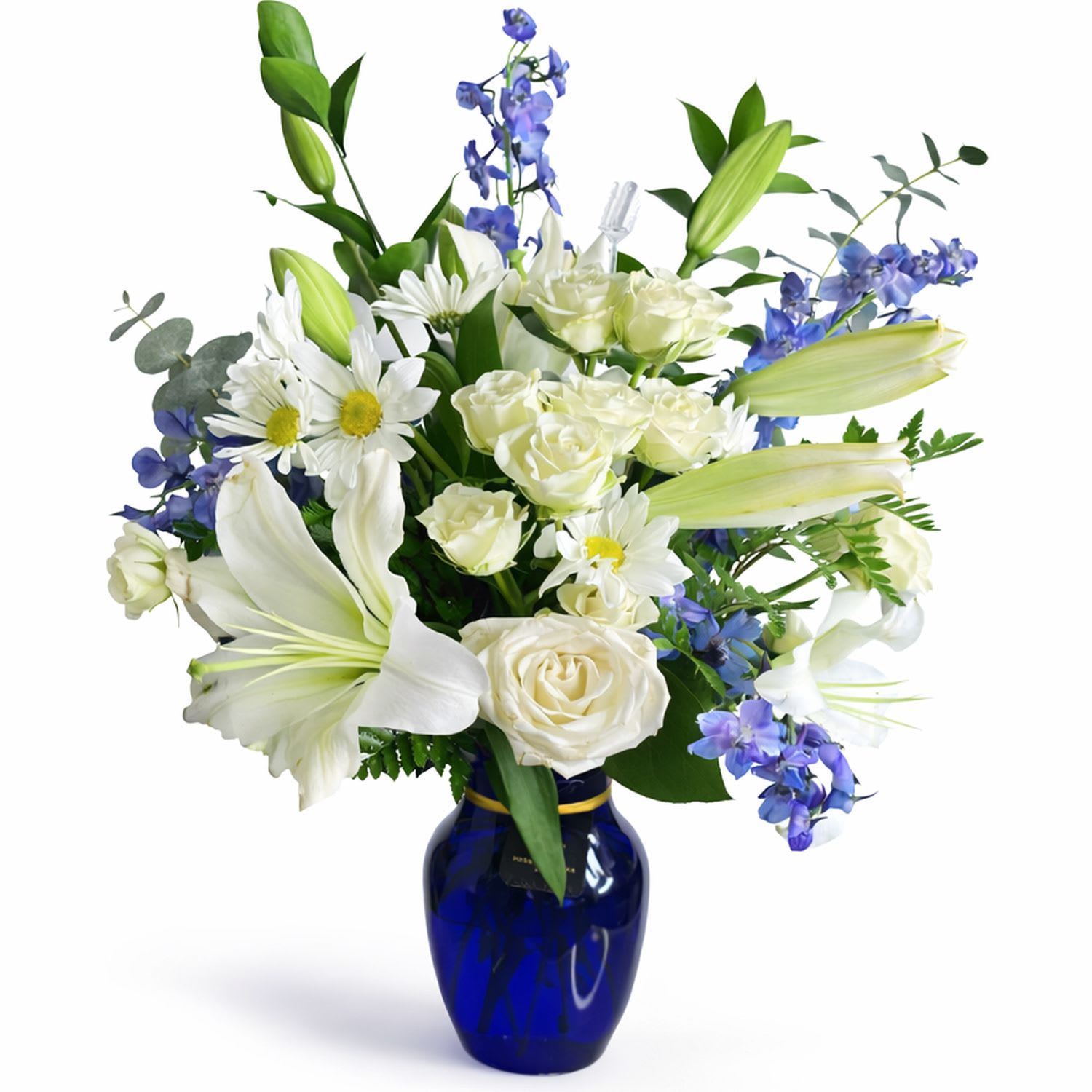 Twillight Grace - Elegant white lilies and rich lavender-toned blooms come together in a striking cobalt blue vase, creating a design that feels both peaceful and refined. This arrangement is a beautiful expression of calm and comfort, with a touch of timeless beauty.  Each piece is Designer’s Choice, created with fresh seasonal blooms. Flowers and colors may vary based on availability while maintaining the overall style and quality.  Better for: Sympathy, Get Well Soon, Mother’s Day, Thank You, New Baby, Thinking of You, Birthday. 