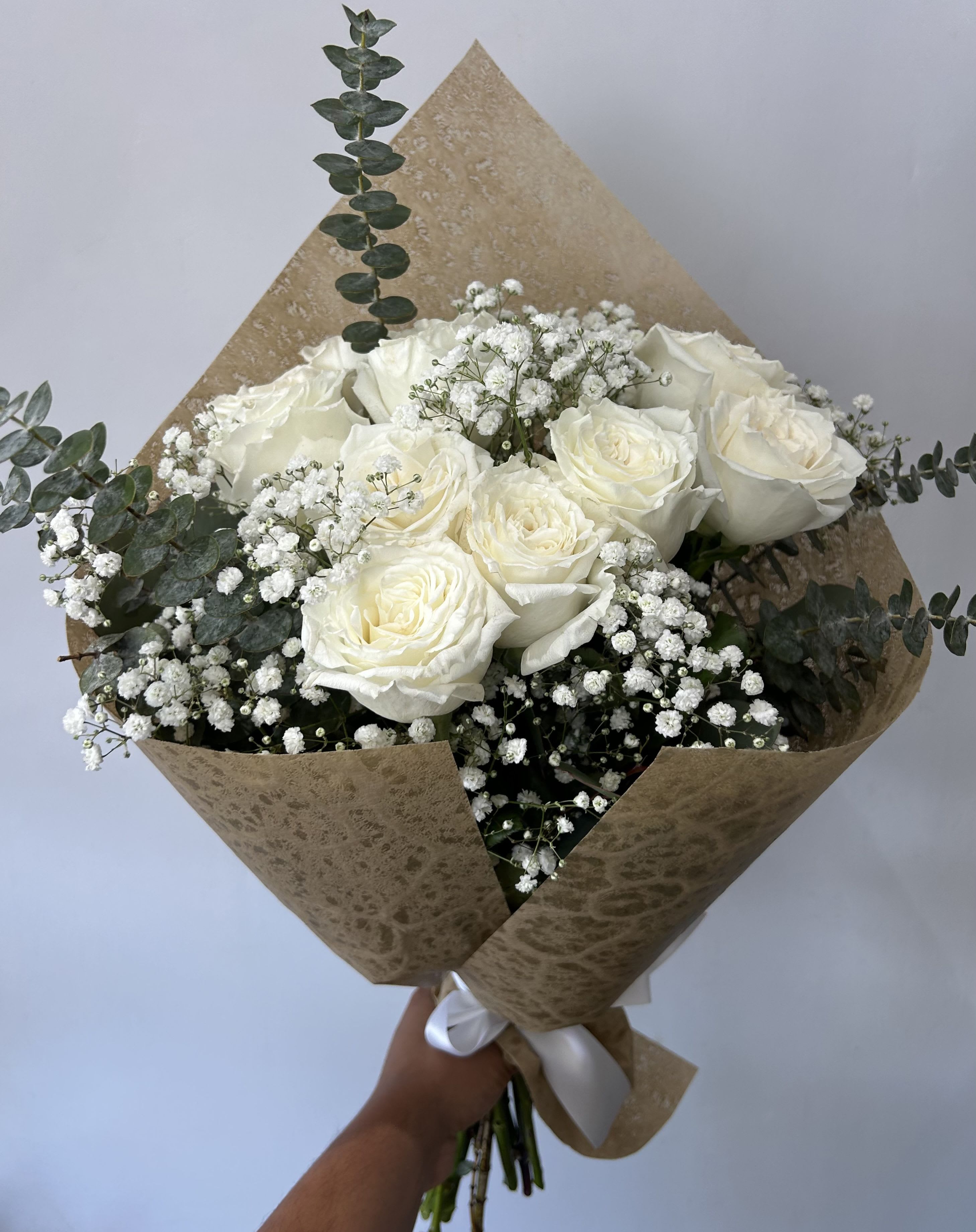 White Roses Bouquet - One dozen white roses arranged into a hand-tied bouquet with fillers and greens. 