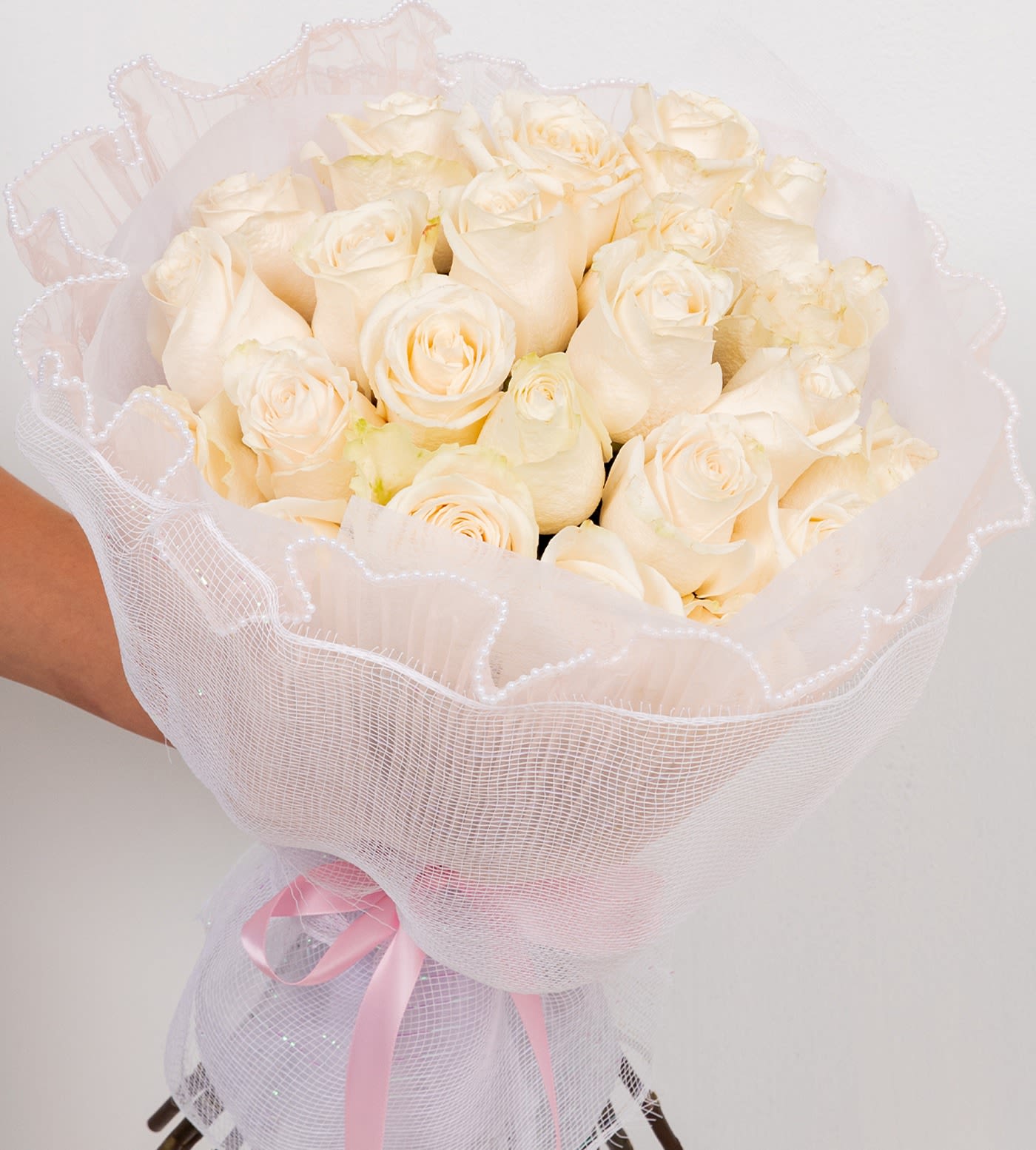Coquette in White  - A round bouquet of two dozen roses. White mesh wrapping with a subtle shimmer, finished with delicate white lace trim with little pearl and a classic ribbon—romantic, elegant, and perfectly coquette. Flowers may vary by season.