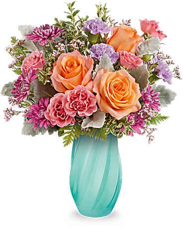 Teleflora's Blue Radiance Bouquet - Brighten their spring with Teleflora's Blue Radiance Bouquet, a joyful mix of orange, pink, and lavender blooms arranged in a sculpted glass vase with a graceful diagonal swirl design-a glowing celebration of warmth and renewal. Teleflora's Blue Radiance Bouquet features light orange roses, pink spray roses, lavender carnations, purple cushion spray chrysanthemums, pink limonium, dusty miller, leatherleaf fern, and oregonia, arranged in Teleflora's Blue Radiance Vase, a sculpted glass vase with a diagonal swirl pattern. Approximately 13 3/4" W x 16 1/2" H