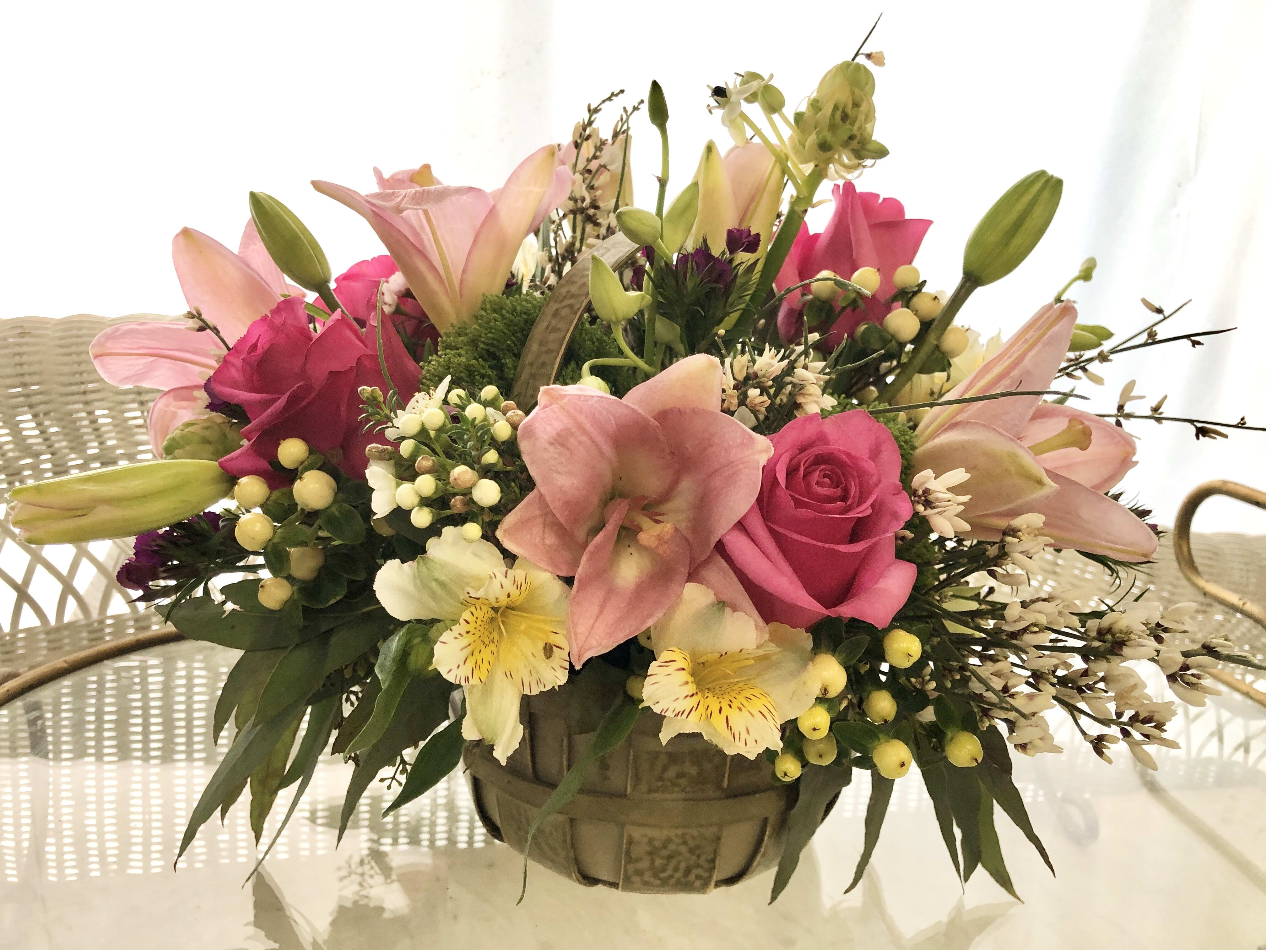 A Spring Surprise - An arrangement of light pinks and yellows with seasonal flowers and greens.
