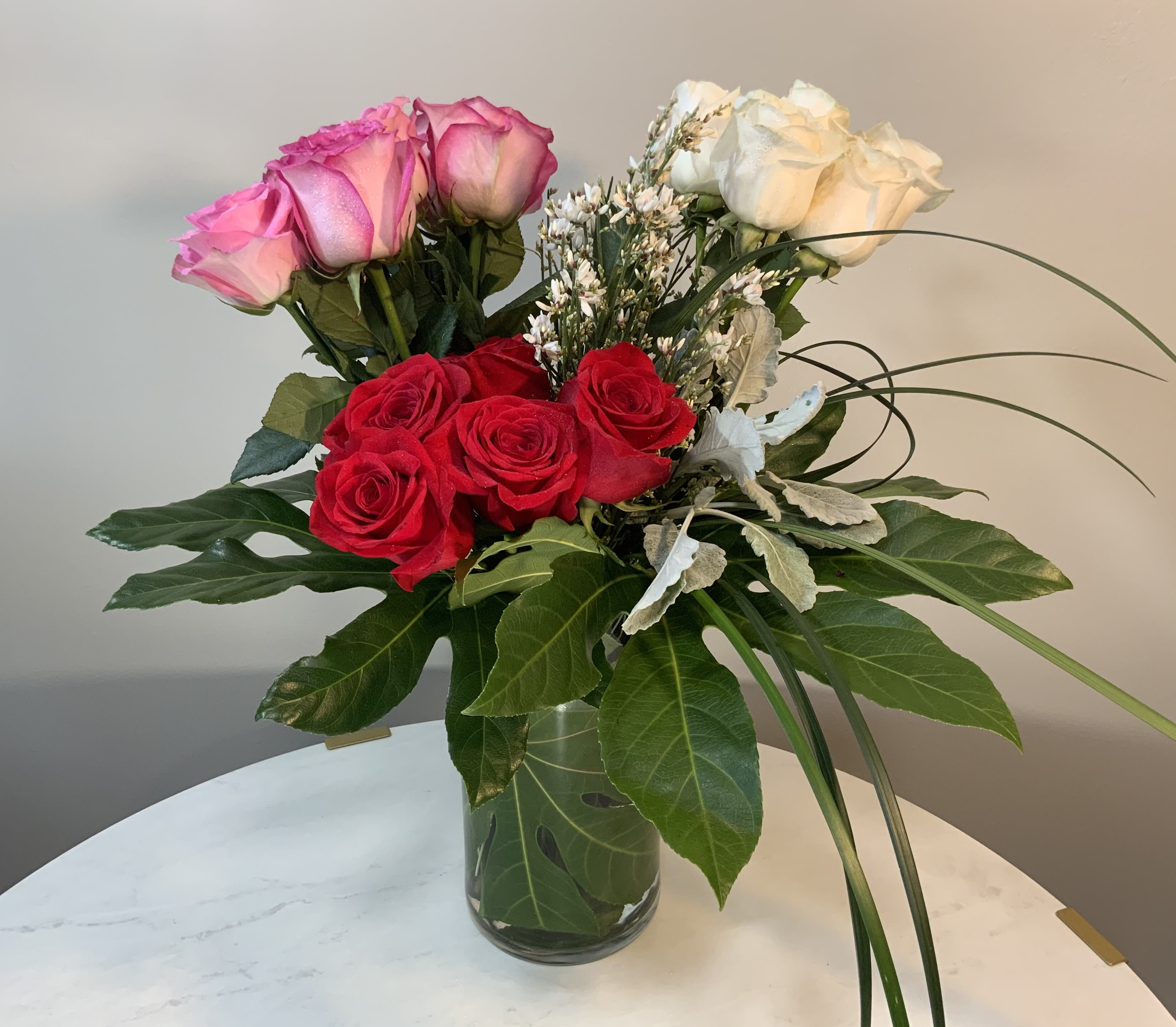 Eighteen roses  - Eighteen beautiful roses accented with spring foliages and genestra (6 x 8 in) in a vase. Not too much, not too little. Just right. Classic, fresh, and real.  Every arrangement is made fresh by hand. No two are identical.   Se habla español.