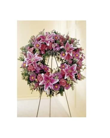 Loving Remembrance Wreath - The Loving Remembrance Wreath is a blushing display of grace and beauty to honor the life of the deceased at their final tribute. Pink roses Oriental lilies gladiolus hydrangea and carnations are brought together with lush greens to form the shape of a wreath offering warmth and comfort with its sweetly sophisticated elegance. Displayed on a wire easel. Approximate Size: 23"d   FCS21-4484