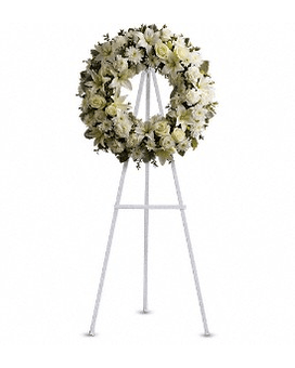 Serenity Wreath - A ring of fragrant bright white blossoms will create a serene display at any funeral or wake. This classic wreath is delivered on an easel and is a thoughtful expression of sympathy and admiration. A standing wreath created from fresh white flowers such as roses Asiatic lilies carnations and cushion spray chrysanthemums - accented with greenery - is delivered on an easel. Approximately 22" W x 22" H Orientation: One-Sided   T239-3Aa