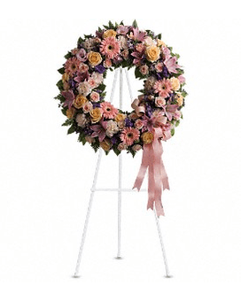 Graceful Wreath - Family and friends will recollect how special their loved one was with this gentle and timeless circle of fragrant blooms to celebrate sweet memories. A mix of flowers such as peach roses gerberas and carnations pink asiatic lilies and lisianthus purple limonium and lavender larkspur nest in greens on an easel-mounted wreath. Approximately 22 1/2" W x 22 1/2" H Orientation: One-Sided   T239-1Aa