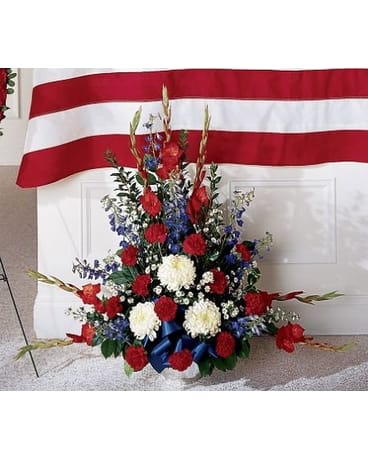 Greater Glory Arrangement - This striking arrangement is a beautiful study in contrasts setting fiery red against pristine white and bold blues. Beautifully accented with assorted greenery and a blue satin bow.   FCS30-3178