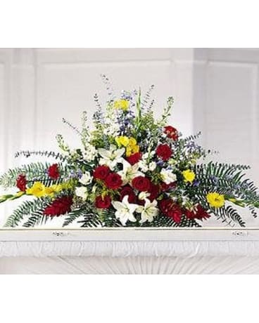Taken Too Soon - Grand spray in brilliant floral colors of red white yellow and blue in an expressive design of Carnations Delphinium Roses and more for use over an open casket.   FCS33-3569