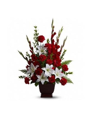 Tender Tribute - Vivid and touching vibrant reds and serene whites blend in honor and celebration of a life filled with love light and grace. Beautiful fresh flowers such as red gladioli and carnations with white asiatic lilies set amidst myrtle sword fern and salal in an exclusive Noble Heritage Urn. Approximately 24" W x 34" H Orientation: One-Sided   FCFT227-1A