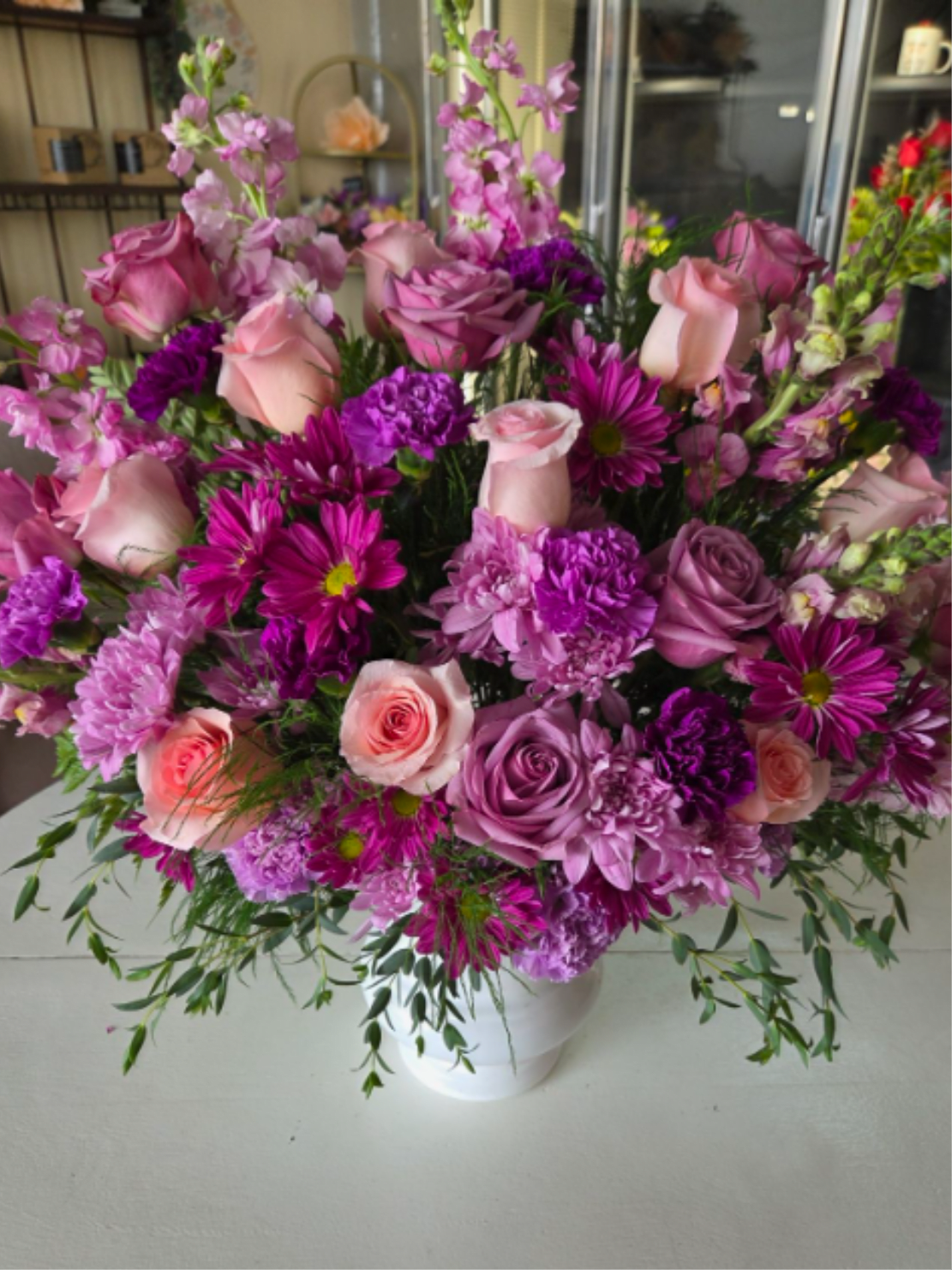 Grace - Grace is a tender and comforting sympathy arrangement in soft shades of blush, lavender, and pink. Featuring elegant roses, carnations, daisies, and lush greenery, this design offers warmth, beauty, and heartfelt remembrance. A graceful tribute to honor a loved one and bring peace to those who mourn.