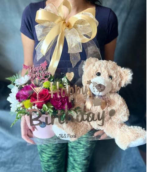 TENDER - Introducing our exquisite Tender in a Purse  – where elegance meets nature's beauty. Embrace the charm of freshly picked flowers, delicately arranged in a stylish purse that exudes sophistication with the cuddly teddy bear. Perfect for every occasion, these blooms are more than a gift; they're a statement. Elevate your gestures with our meticulously curated floral purses, a fusion of timeless romance and contemporary design.   It comes with a flower box and a 14" teddy bear and it can be customized depending on your occasion. 