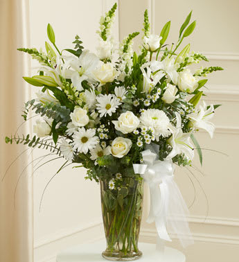 Beautiful Blessings White Vase Arrangement - Product ID: 91302   Finding the perfect tribute to convey all the sympathy you feel at this sad time can be difficult. This lovely arrangement of fresh white blooms is expertly crafted by our florists to help you offer your comfort, support and hope in a simple yet elegant way. Hand-designed arrangement of fresh white roses, hybrid lilies, cremones and more Accented with myrtle, spiral eucalyptus and more Presented in a classic clear glass vase; measures 11"H Can be delivered directly to the funeral home or to the home of the family Our florists choose only the freshest flowers available, so colors and varieties may vary Arrangement measures approximately 34"H x 28"L