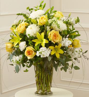 Beautiful Blessings Yellow Vase Arrangement - Product ID: 91298   Our florists use their expert skills and artistic abilities to create an elegant sympathy arrangement that includes yellow flowers as a symbol of friendship and hope, and white blooms to signify reverence and peace. Itâs a beautiful, fitting final tribute for a beloved family member, friend or colleague. Hand-designed arrangement of fresh yellow roses, white football mums, stock, snapdragons and more Accented with salal, seeded eucalyptus and more Presented in a footed clear glass vase; measures 11"H Can be sent to the home of friends, family members or business associates, or directly to the funeral service Our florists choose only the freshest flowers available, so colors and varieties may vary Arrangement measures approximately 26"H