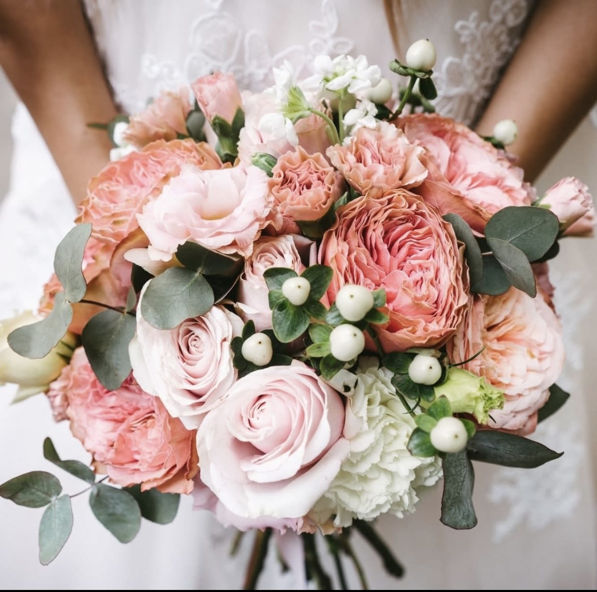 hand held bridal bouquet with pink and white roses  - standard roses , spray roses , hydrangea and white hypericum , eucalyptus  hand tied with ribbon  