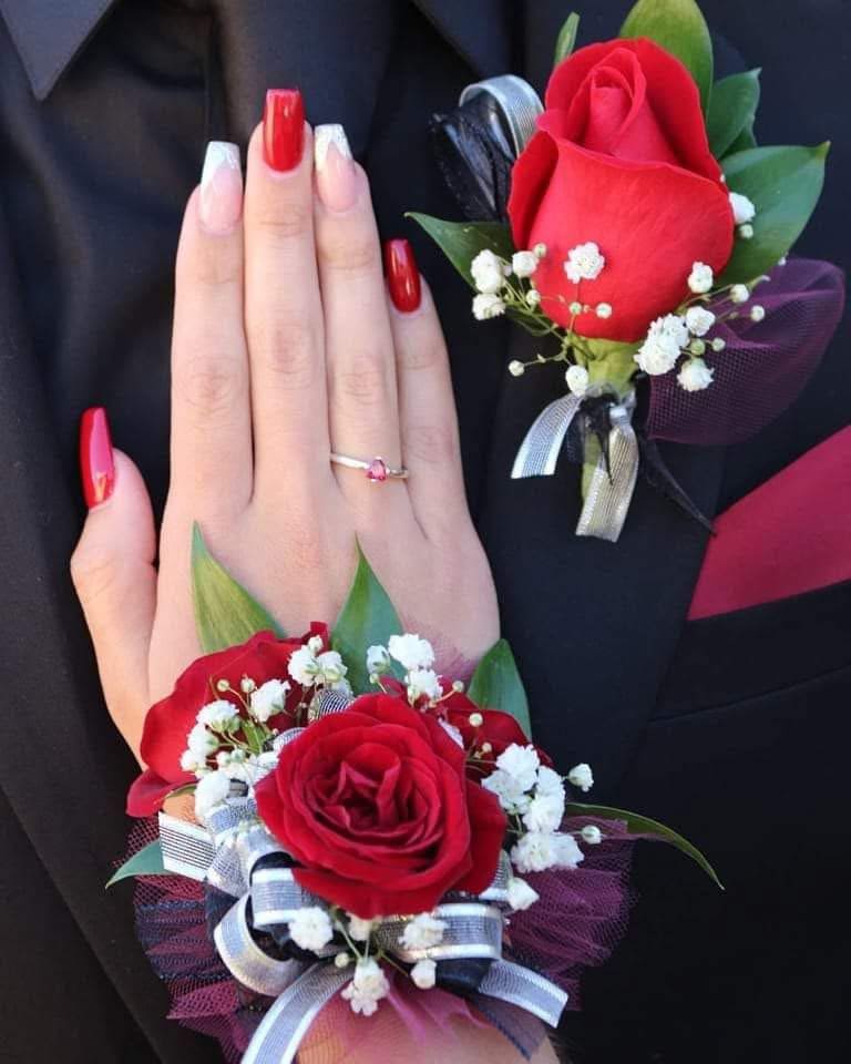 The Crimson Couture Set - This luxury wrist corsage and coordinating boutonniere feature a premium, hand-selected red rose layered with delicate baby’s breath and lush greenery. Finished with dramatic black tulle and satin ribbon accents, the design is bold, refined, and timeless. Perfect for: • Prom Night 2026 • Senior Ball • Formal Dances • Graduation Celebrations