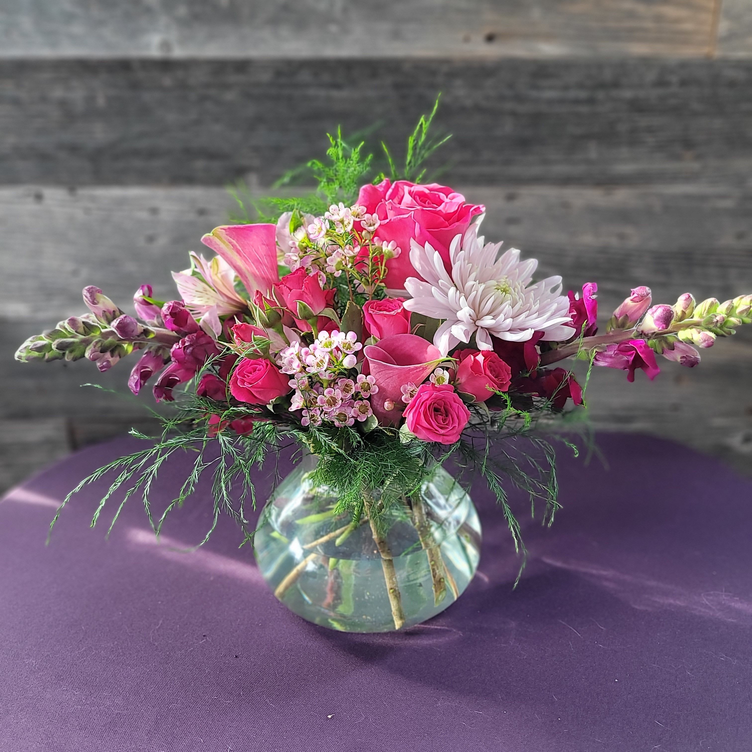 Petal Promenade - A delicate arrangement of flowers featuring Calla lilies and snapdragons .